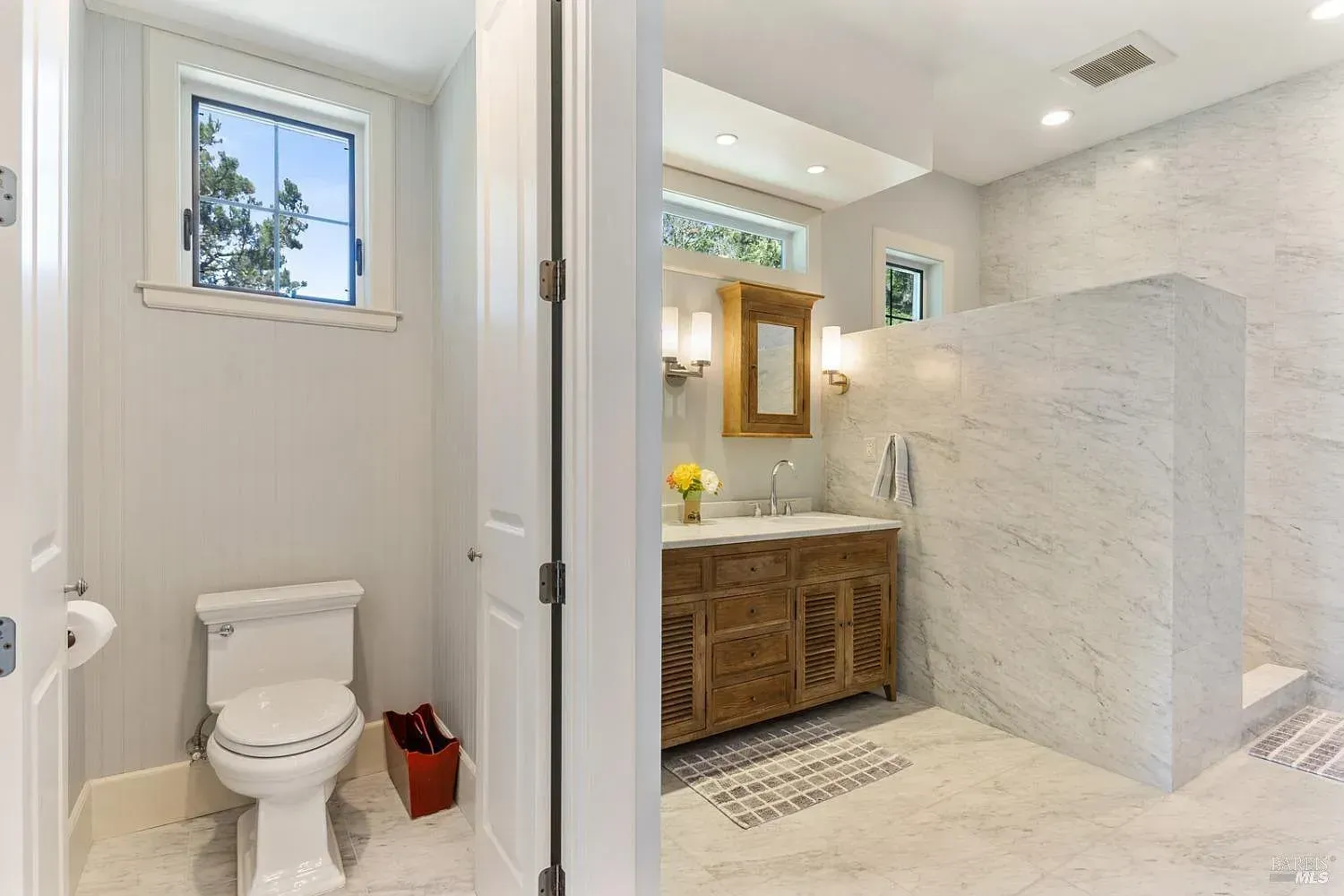 a bathroom with a toilet, sink, and walk-in shower