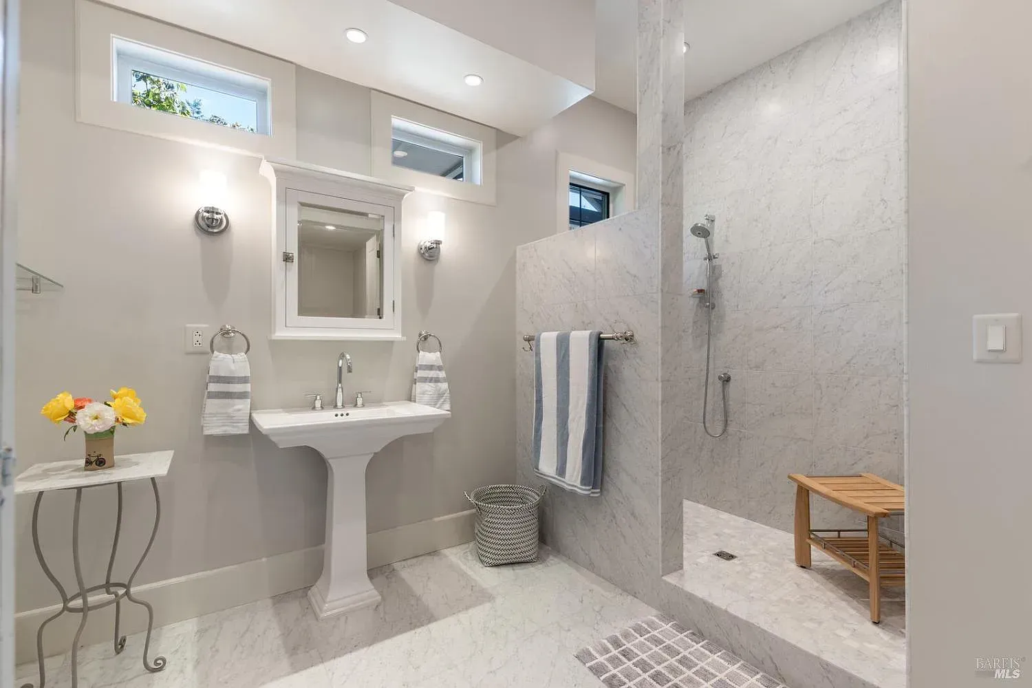 a bathroom with a sink, mirror, and walk-in shower