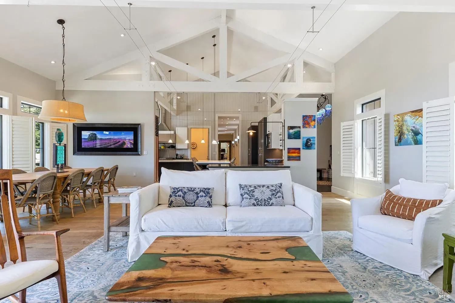a living room with a couch, chairs, table and television