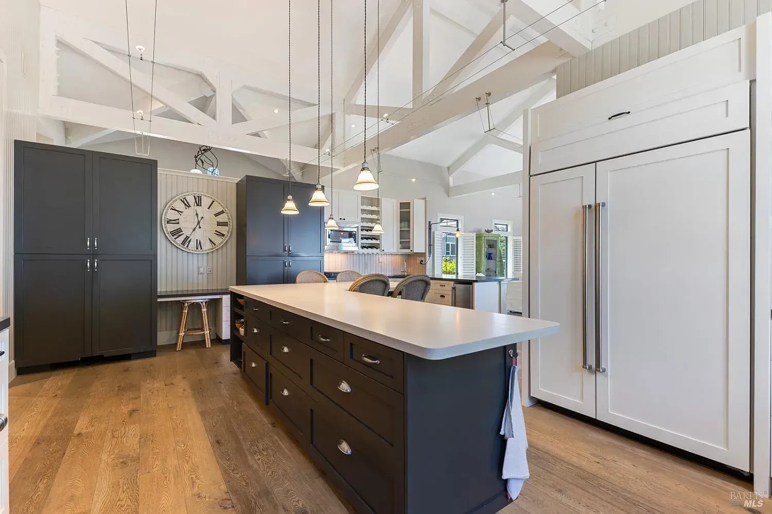a kitchen with a large island and a clock on the wall