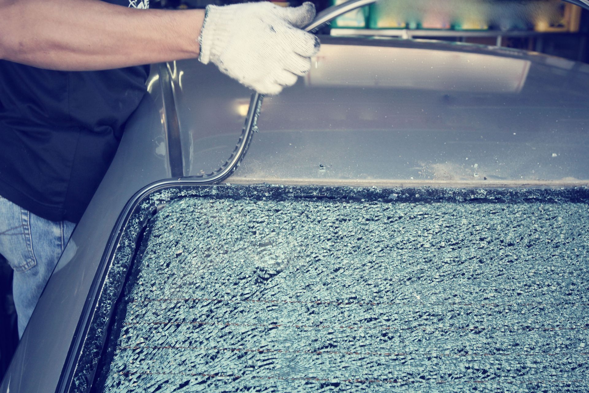 Person washing a car windshield with soapy water and a squeegee