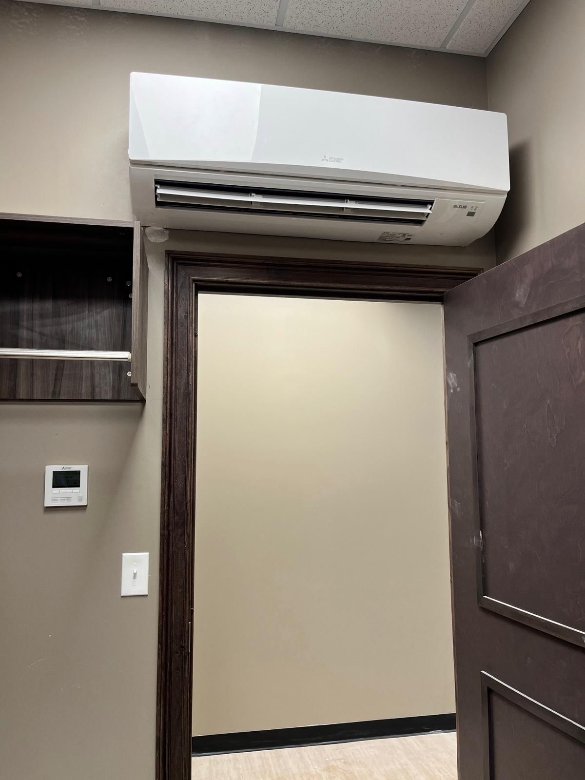 Hallway doorway with a wall-mounted air conditioner above the frame
