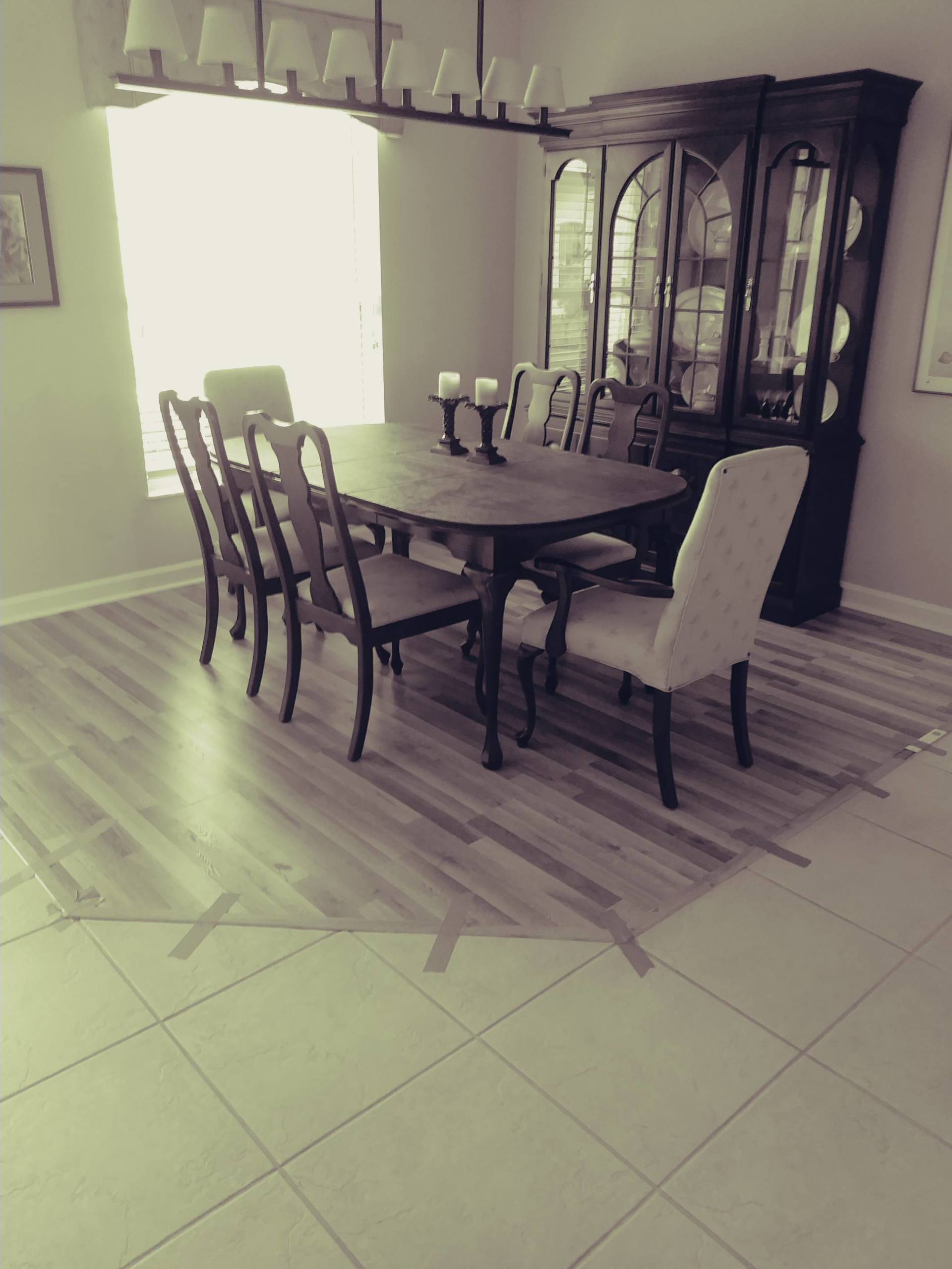 A black and white photo of a dining room with a table and chairs