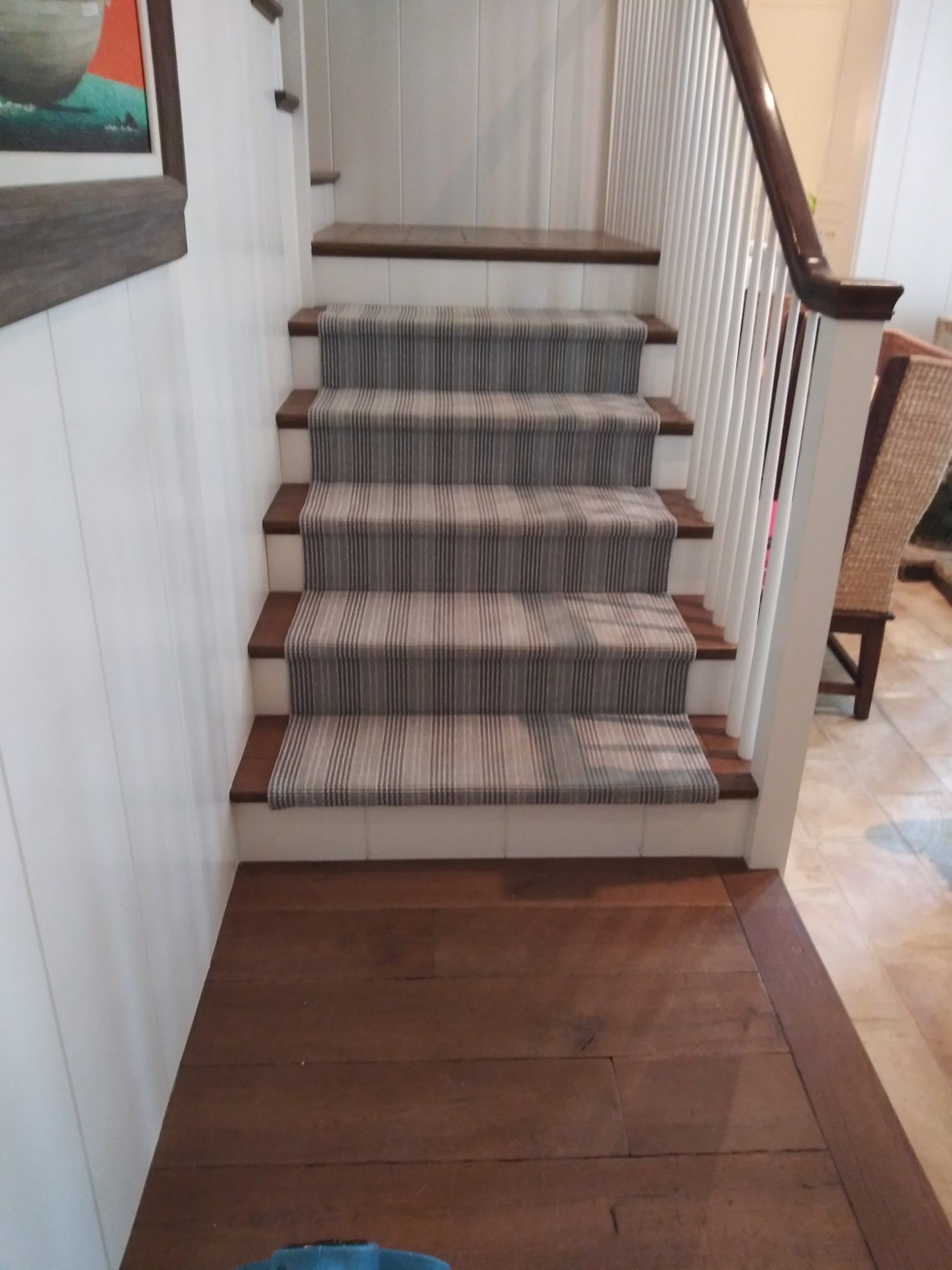 A wooden staircase with a carpet on the steps