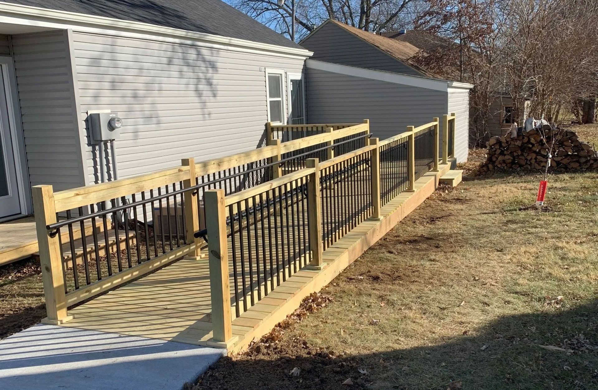 Wooden ramp with black railings leading to a building's entrance.