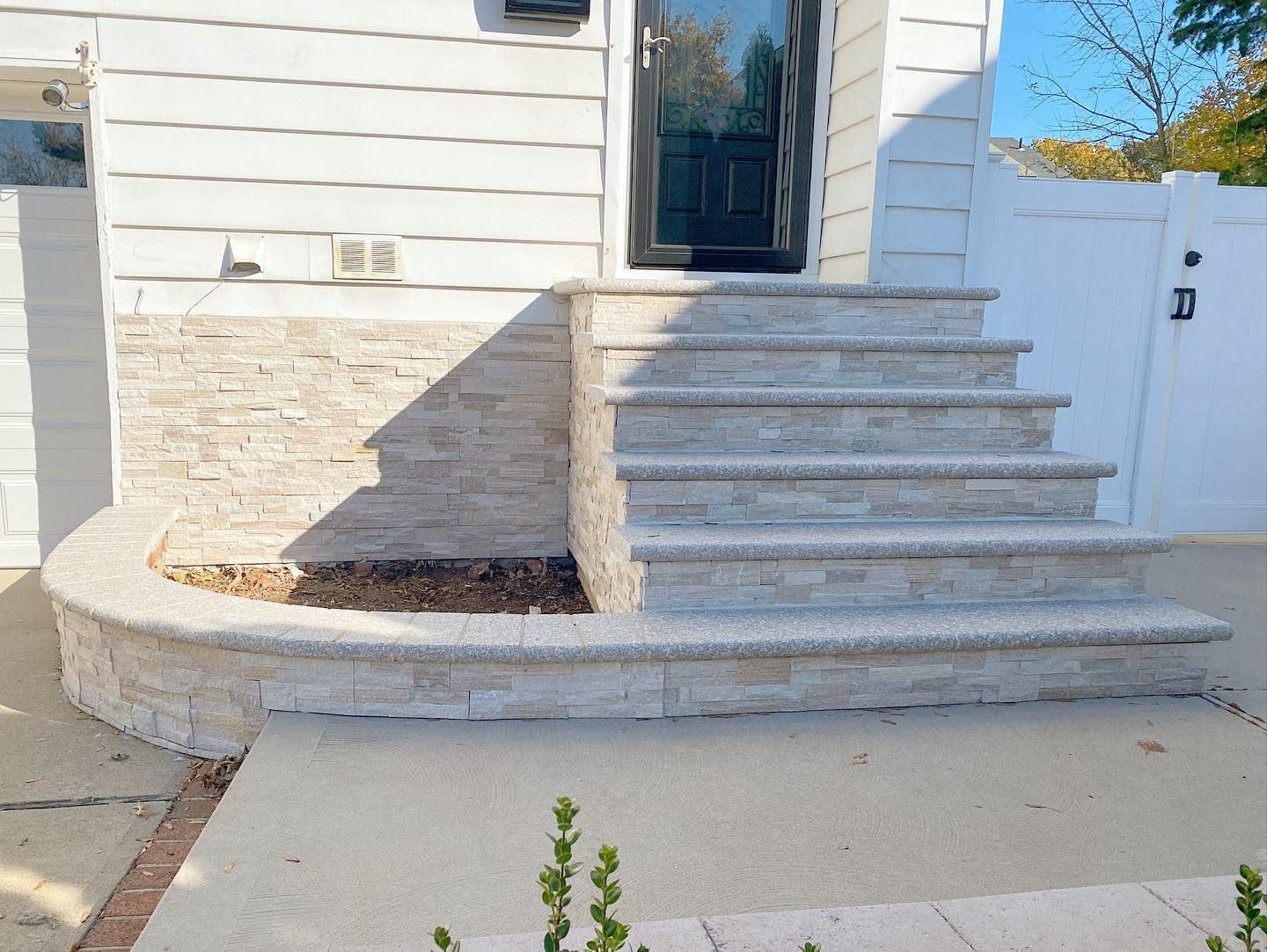 A white house with stairs leading up to the front door