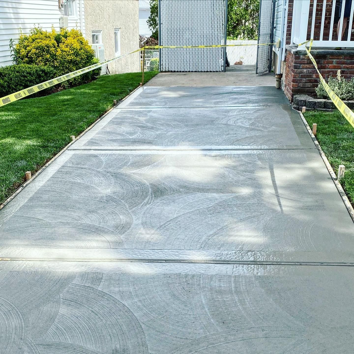 A concrete driveway is being built in front of a house.