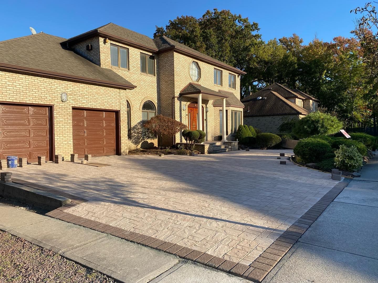 A large house with two garage doors and a brick driveway
