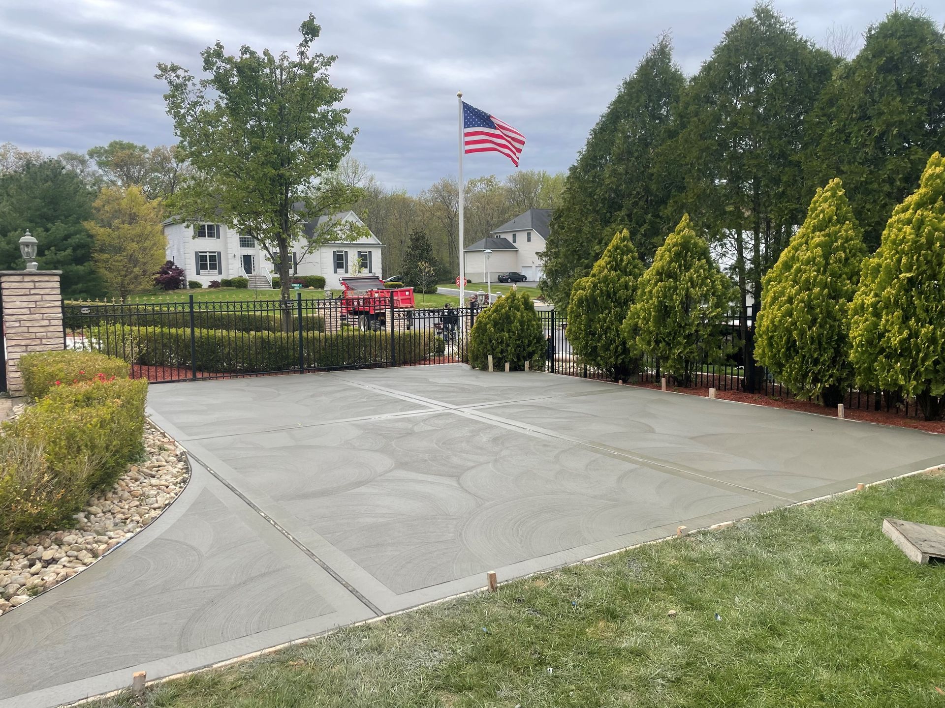A driveway with an American flag flying in the background.