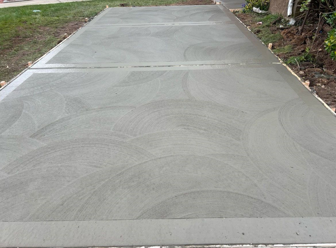 A concrete driveway is being built in front of a house.
