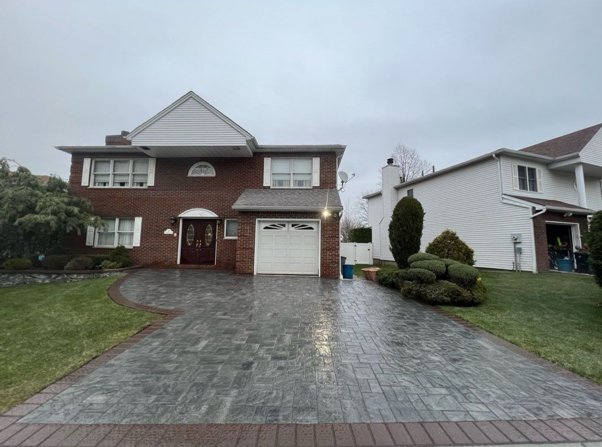 A large brick house with a driveway in front of it.
