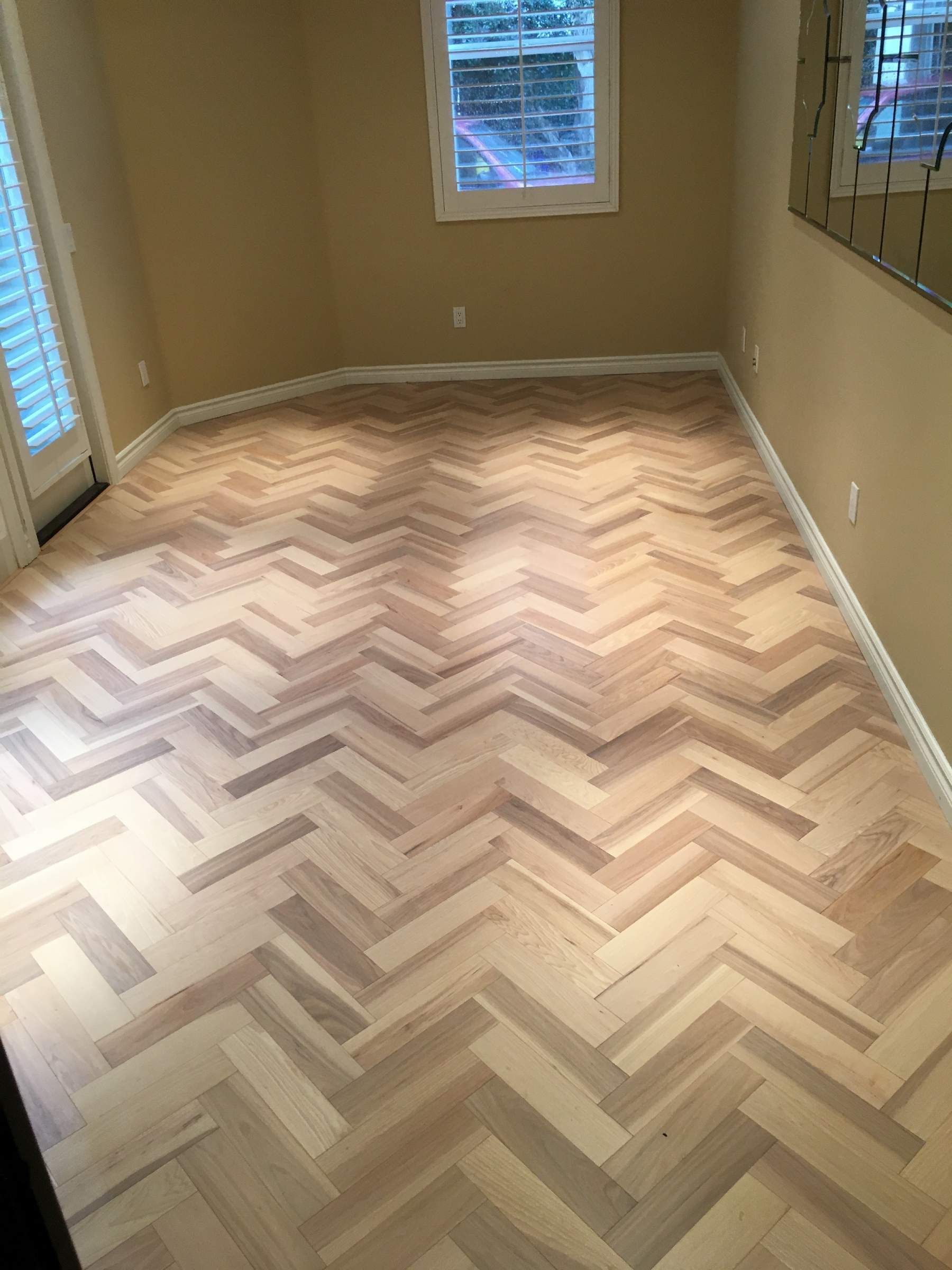 A room with a wooden floor in a herringbone pattern.