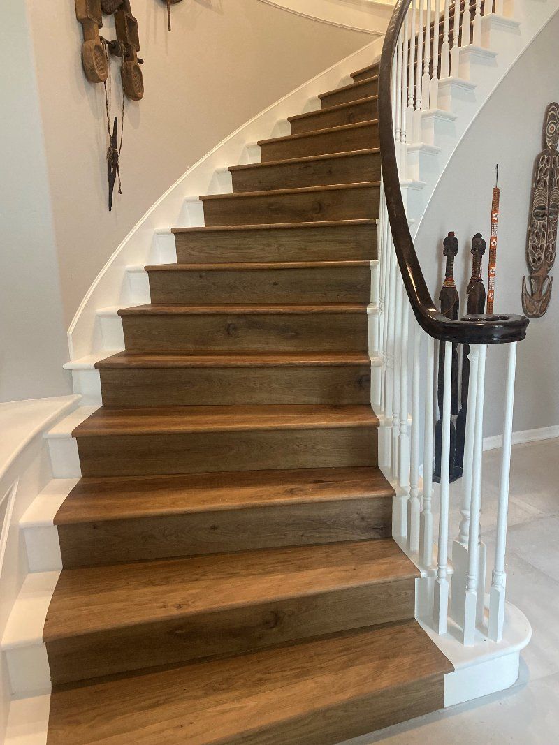 A curved staircase with wooden steps and a white railing.