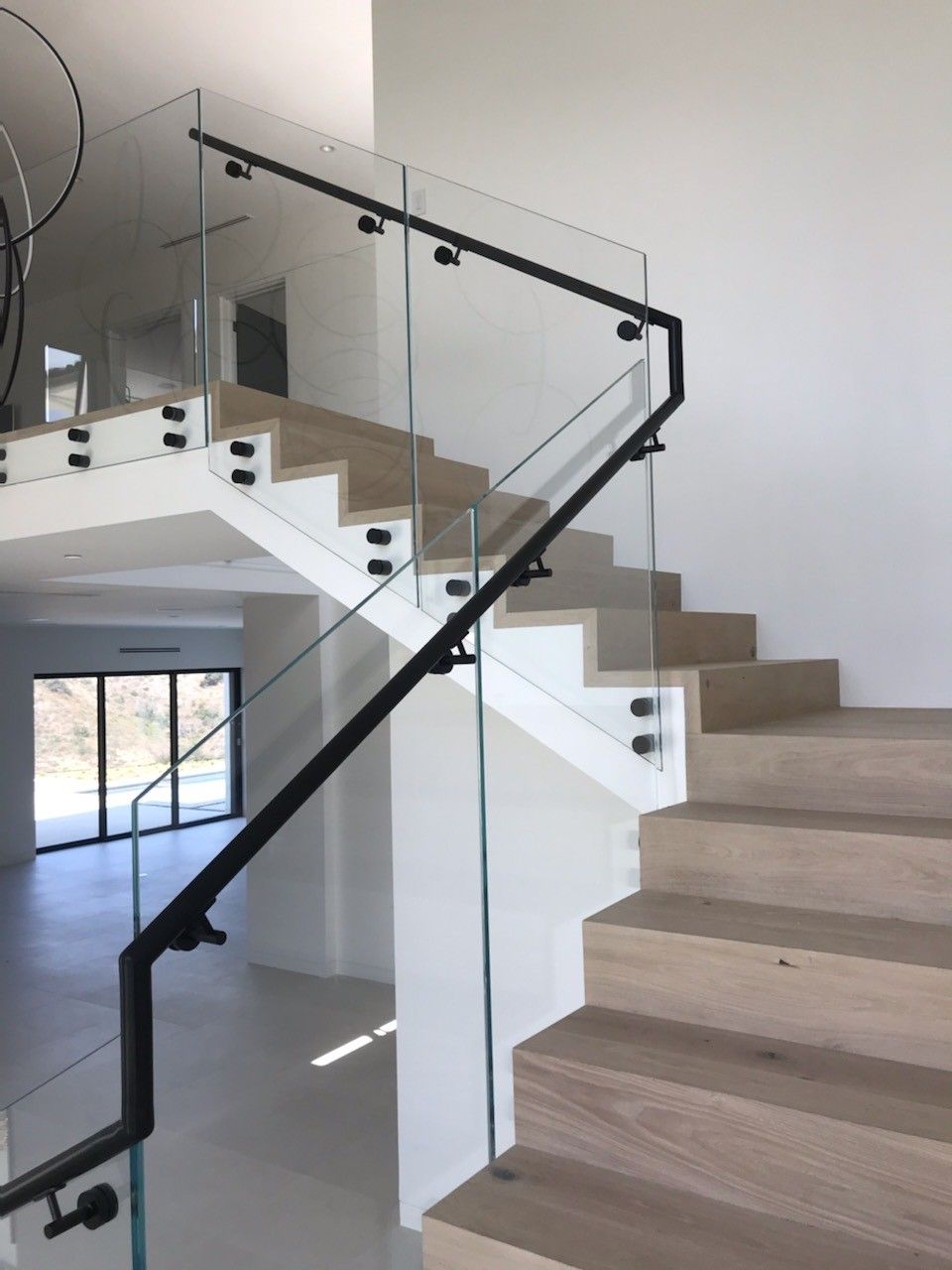 A staircase with a glass railing and wooden steps