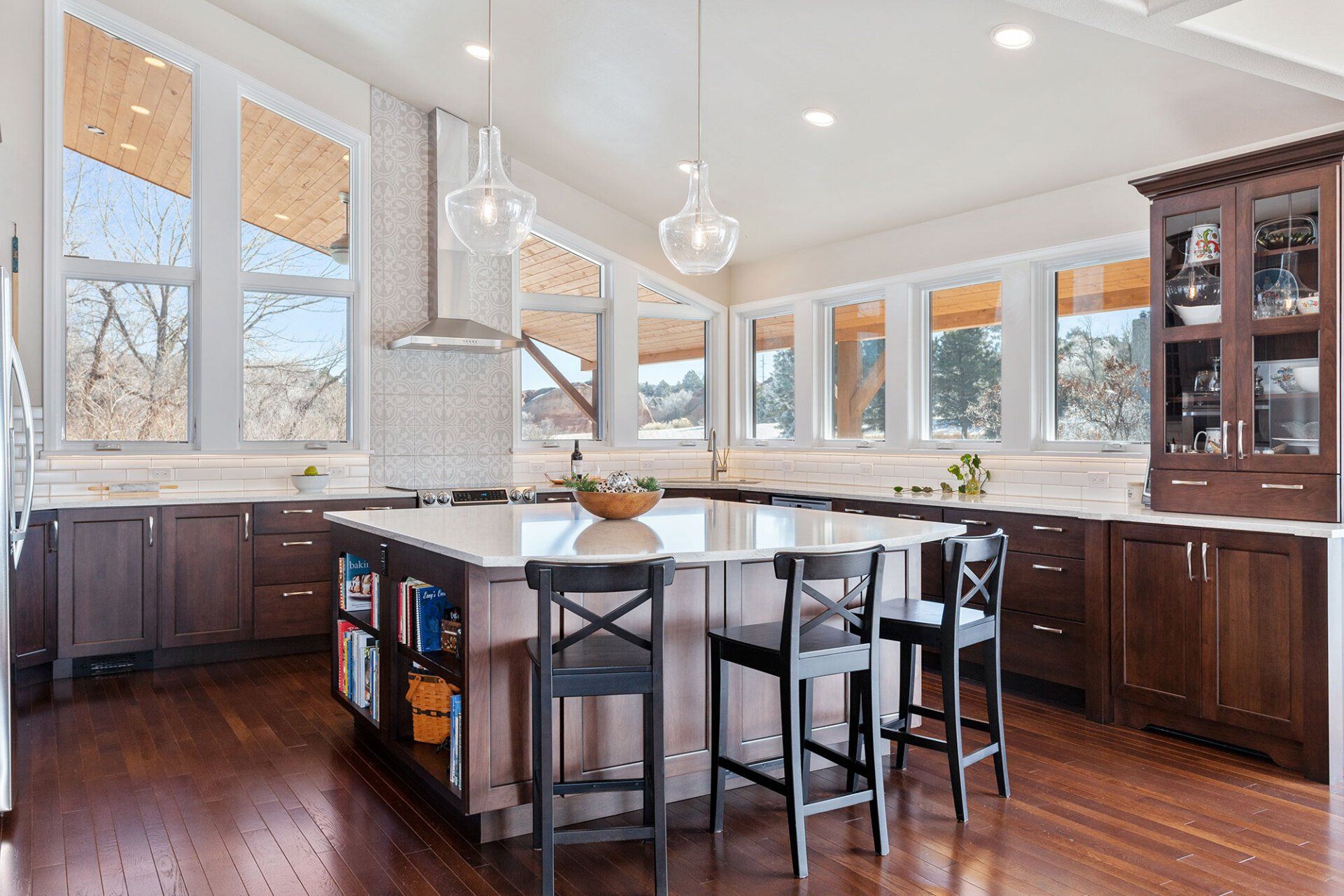 A large kitchen with a large island in the middle and lots of windows.