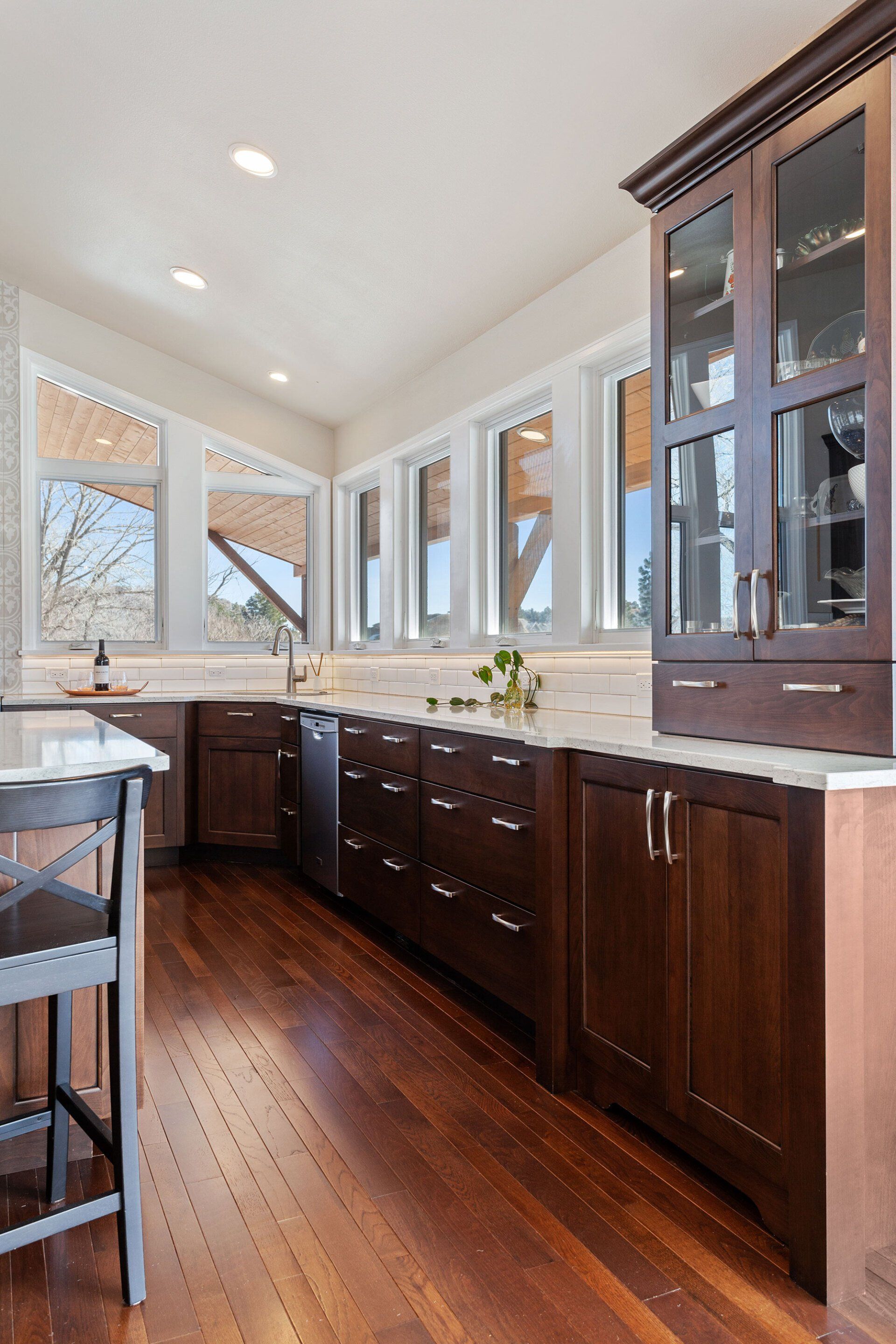 A kitchen with wooden cabinets , marble counter tops , and stainless steel appliances.