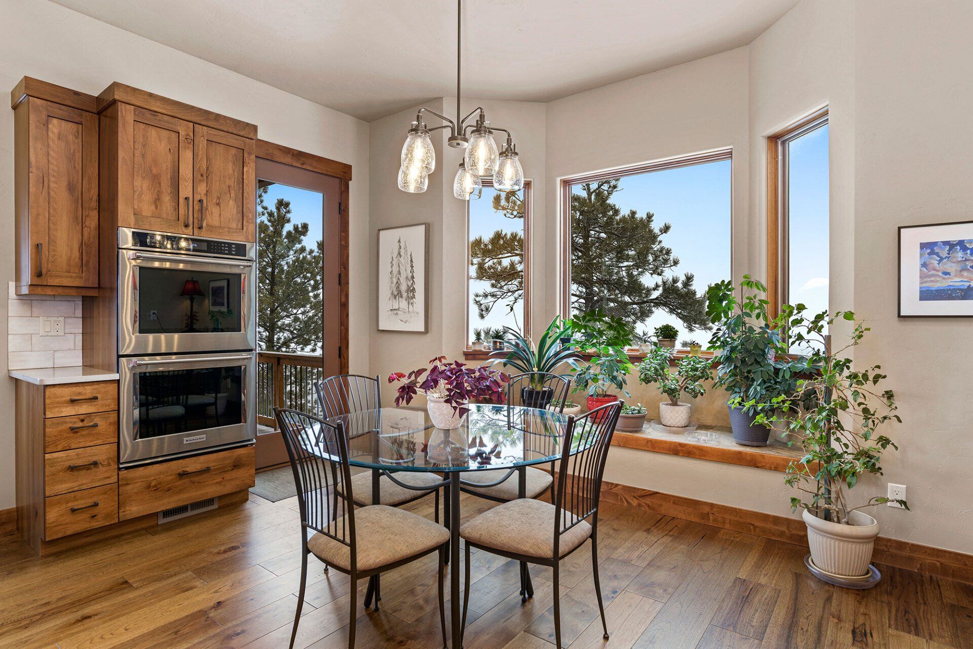 A dining room with a round table and chairs and a large window.