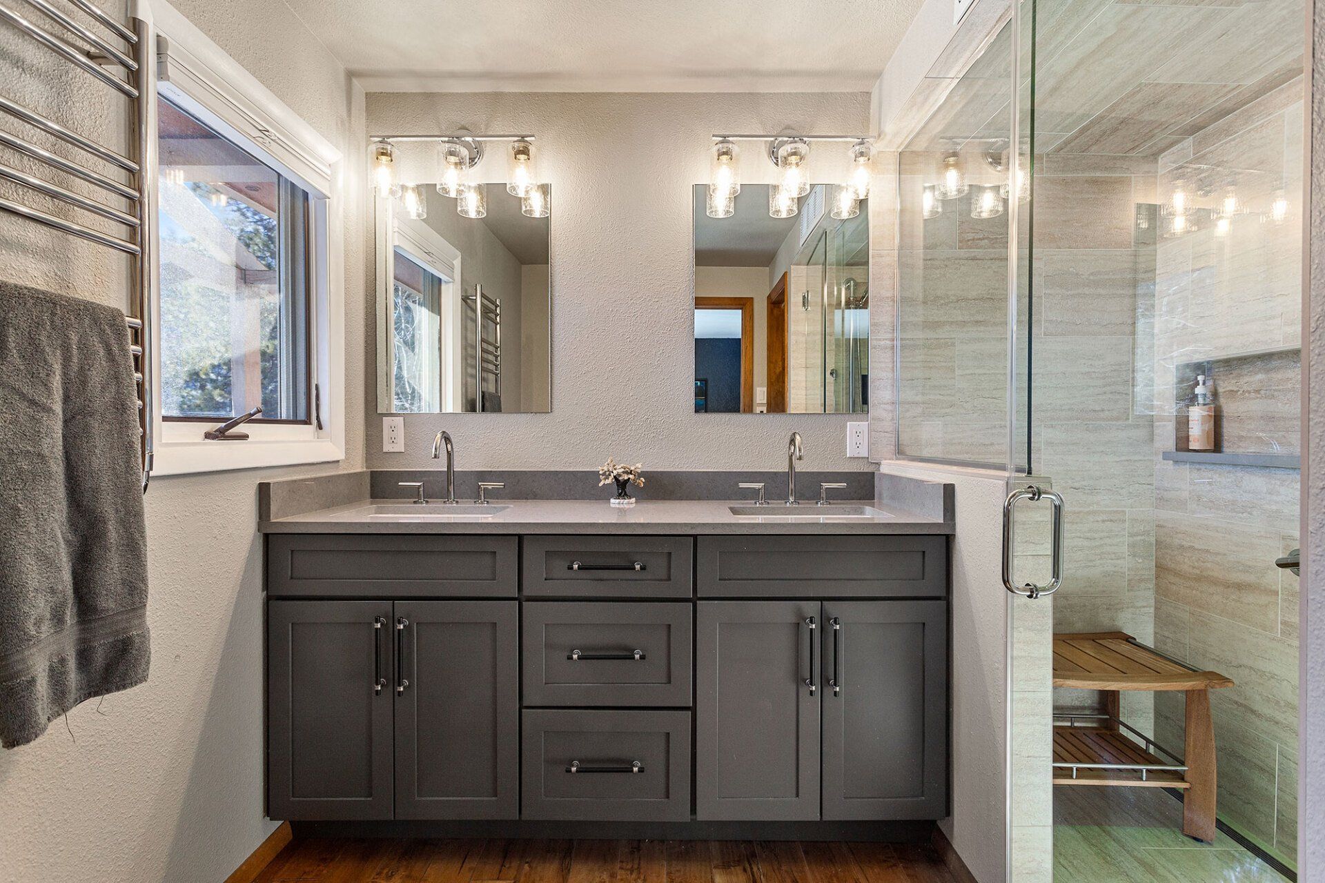 A bathroom with two sinks and a walk in shower.
