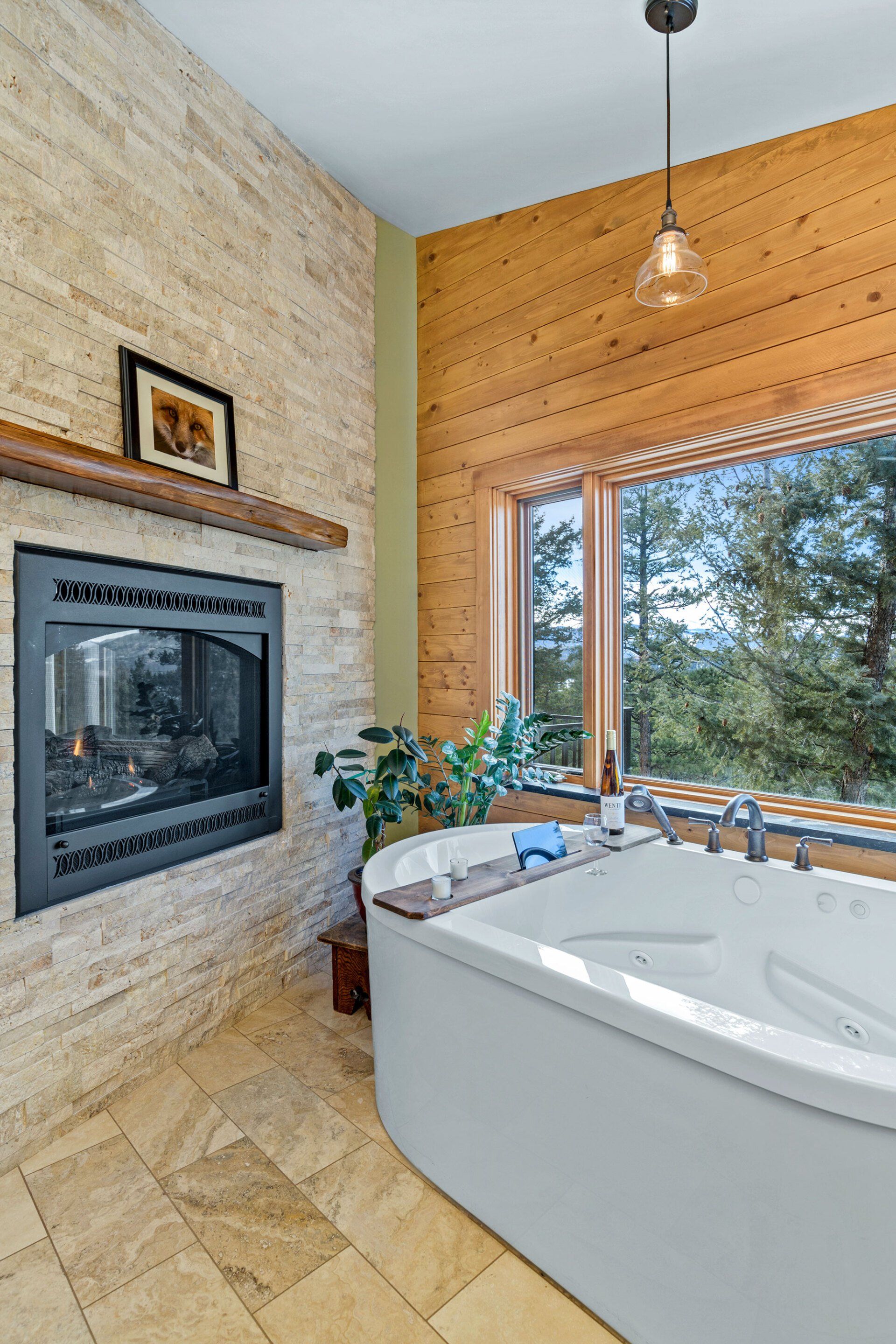 A bathroom with a tub , fireplace and window.