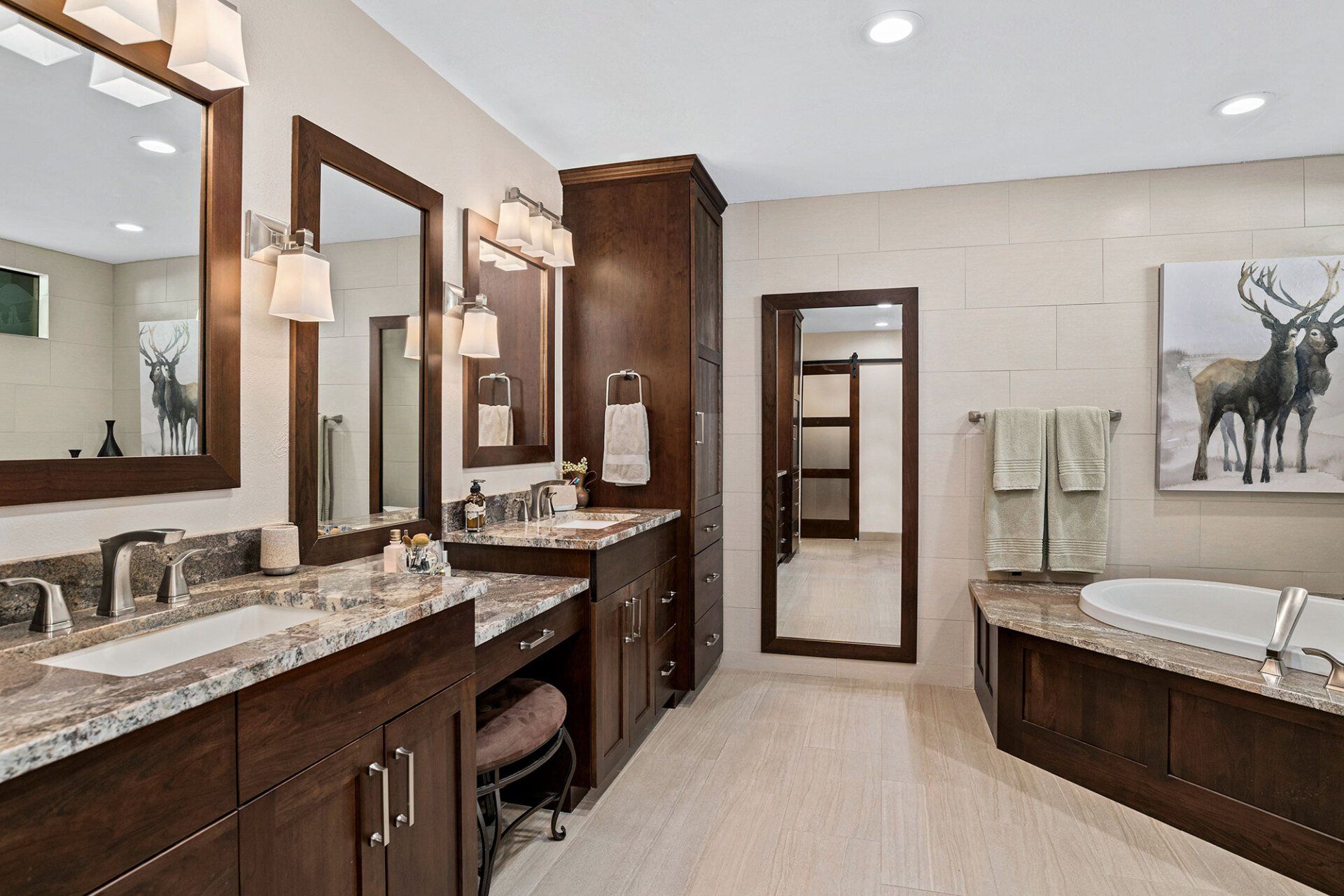 A bathroom with two sinks , two mirrors and a tub.