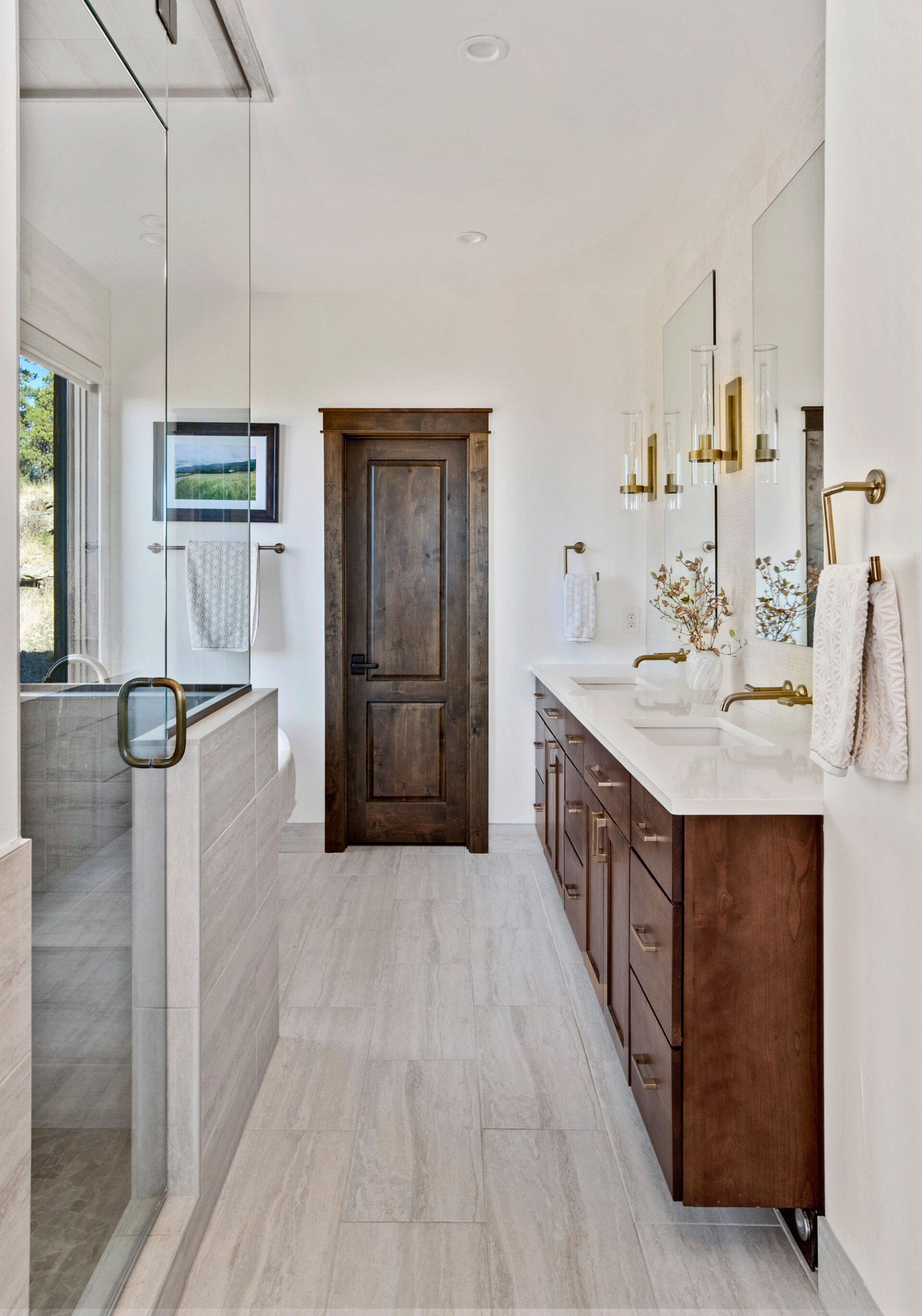 A bathroom with two sinks and a walk in shower.