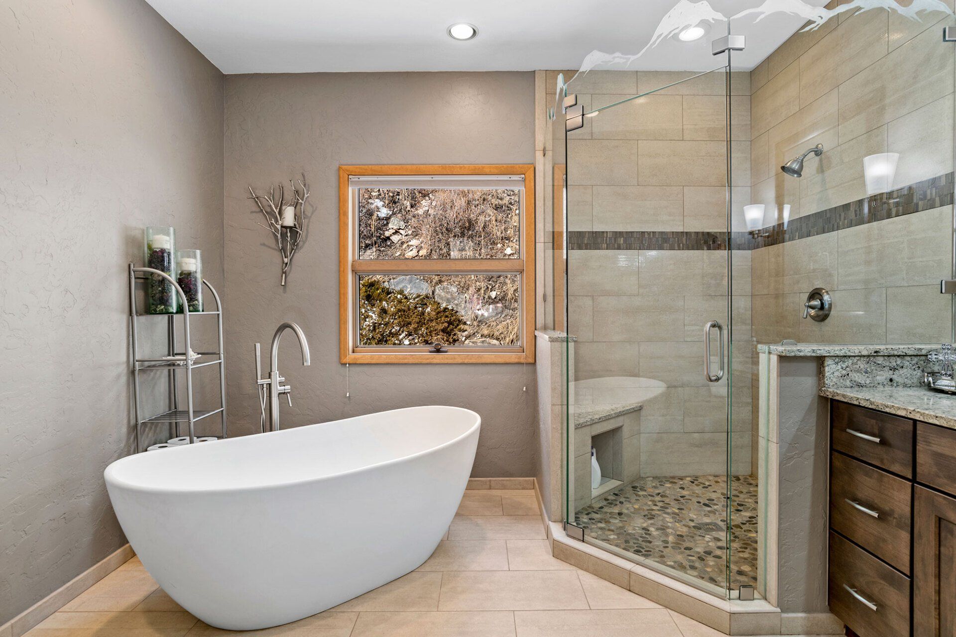 A bathroom with a tub , shower , sink and window.