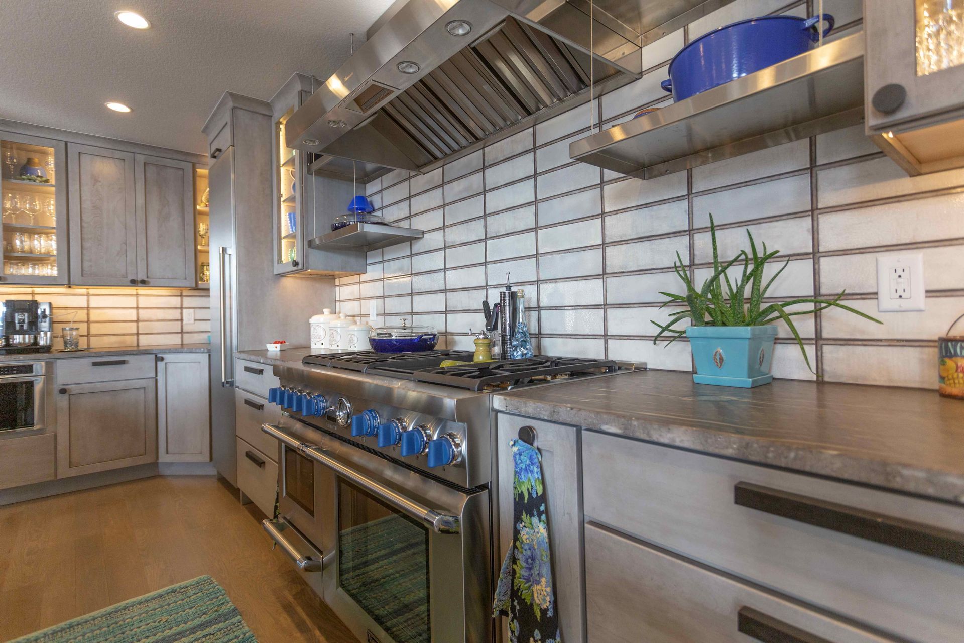 A kitchen with a stove , oven , refrigerator , and cabinets.