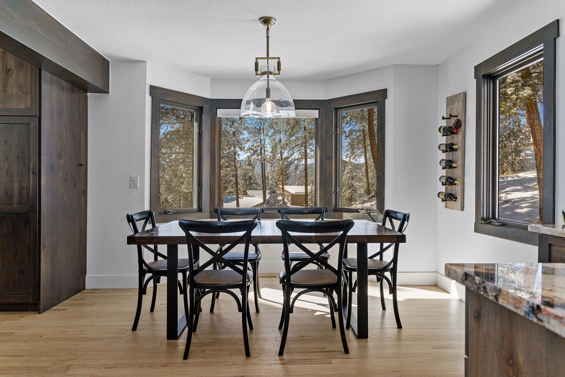 A dining room with a table and chairs and a large window.