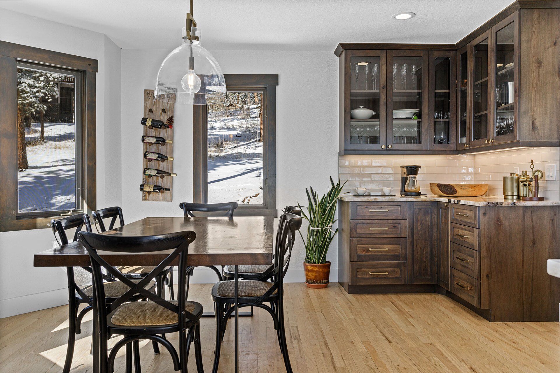 A dining room with a table and chairs and a kitchen.