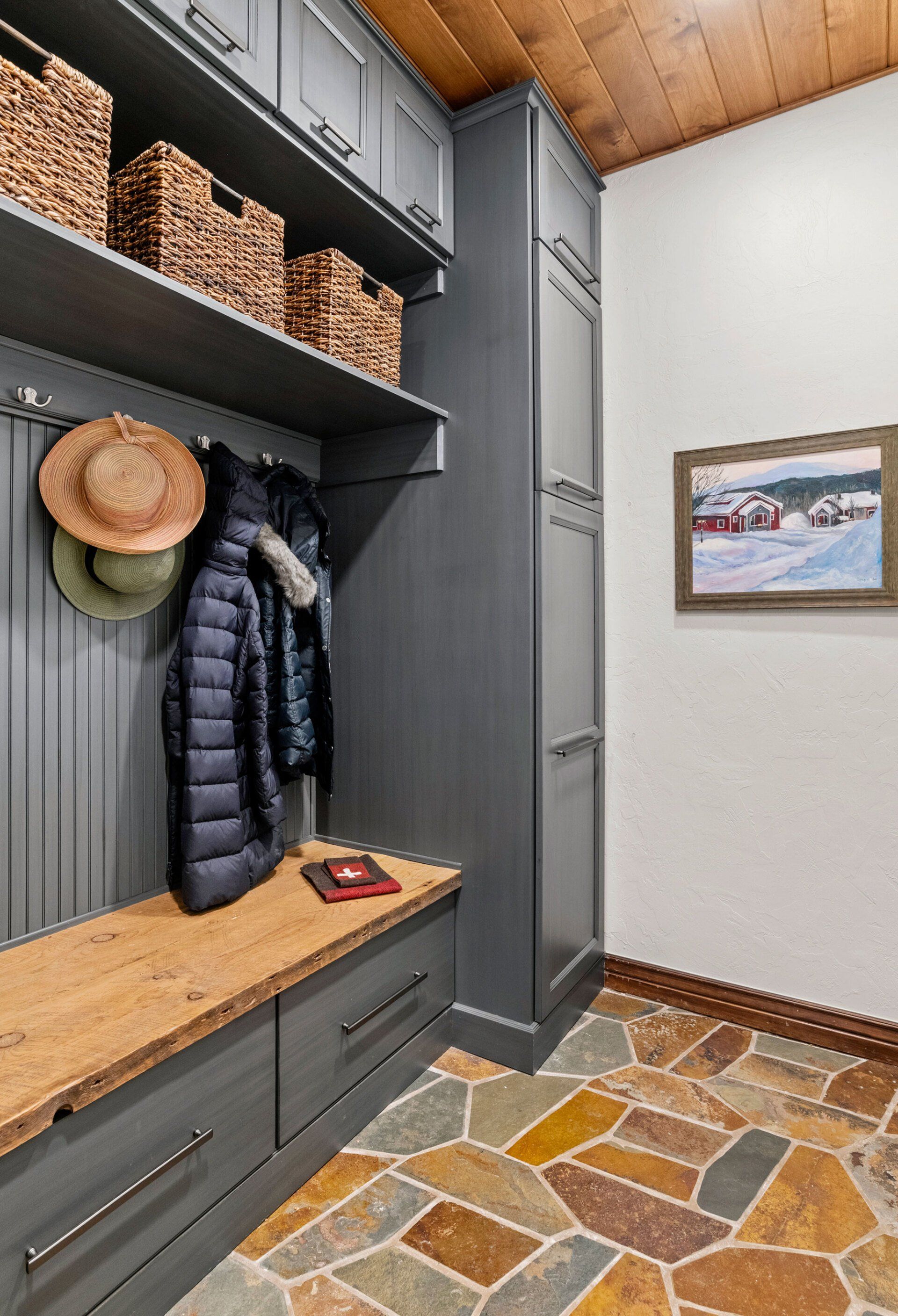 A mud room with a bench and a picture on the wall.