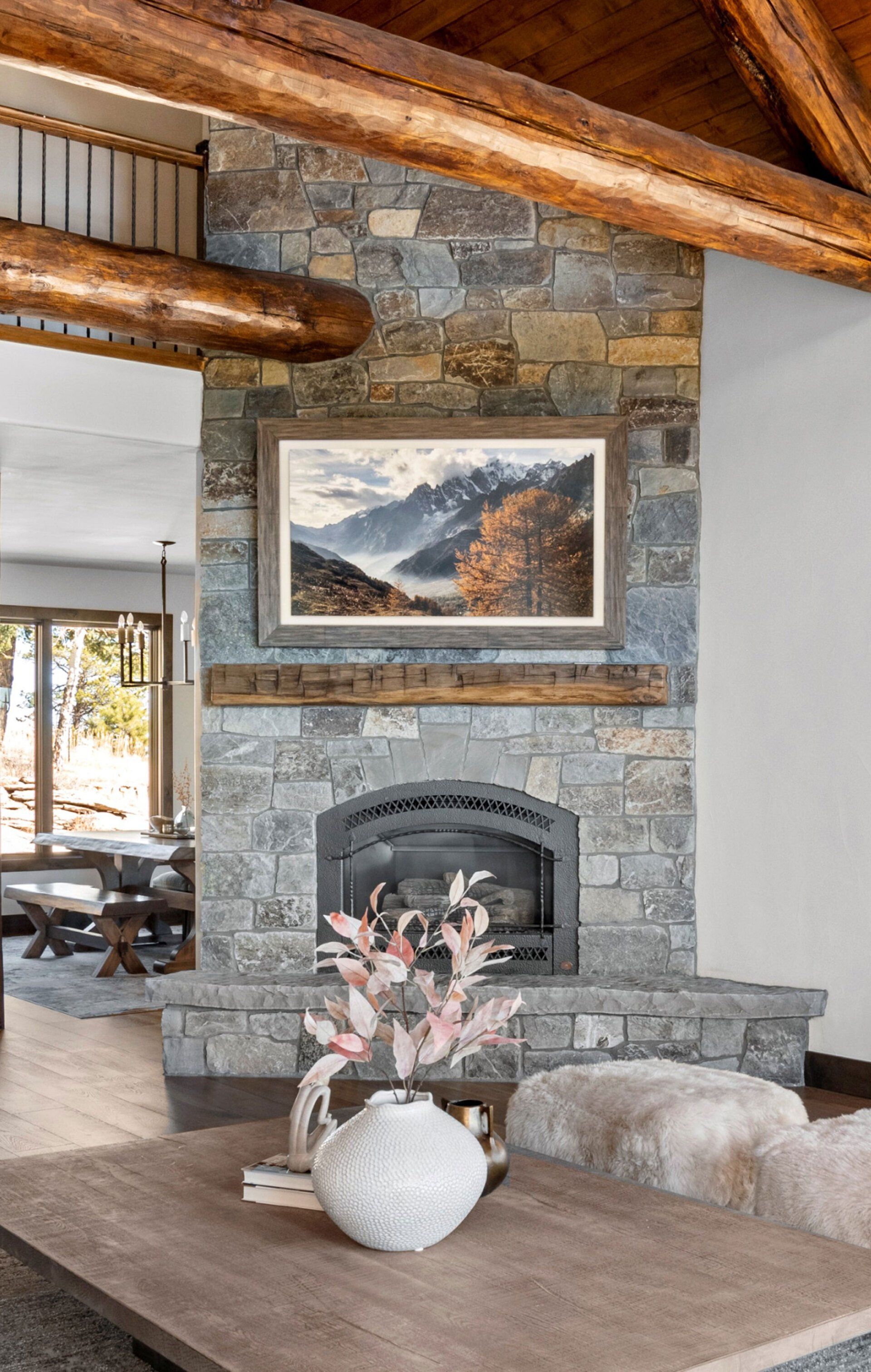 A living room with a fireplace and a painting on the wall.