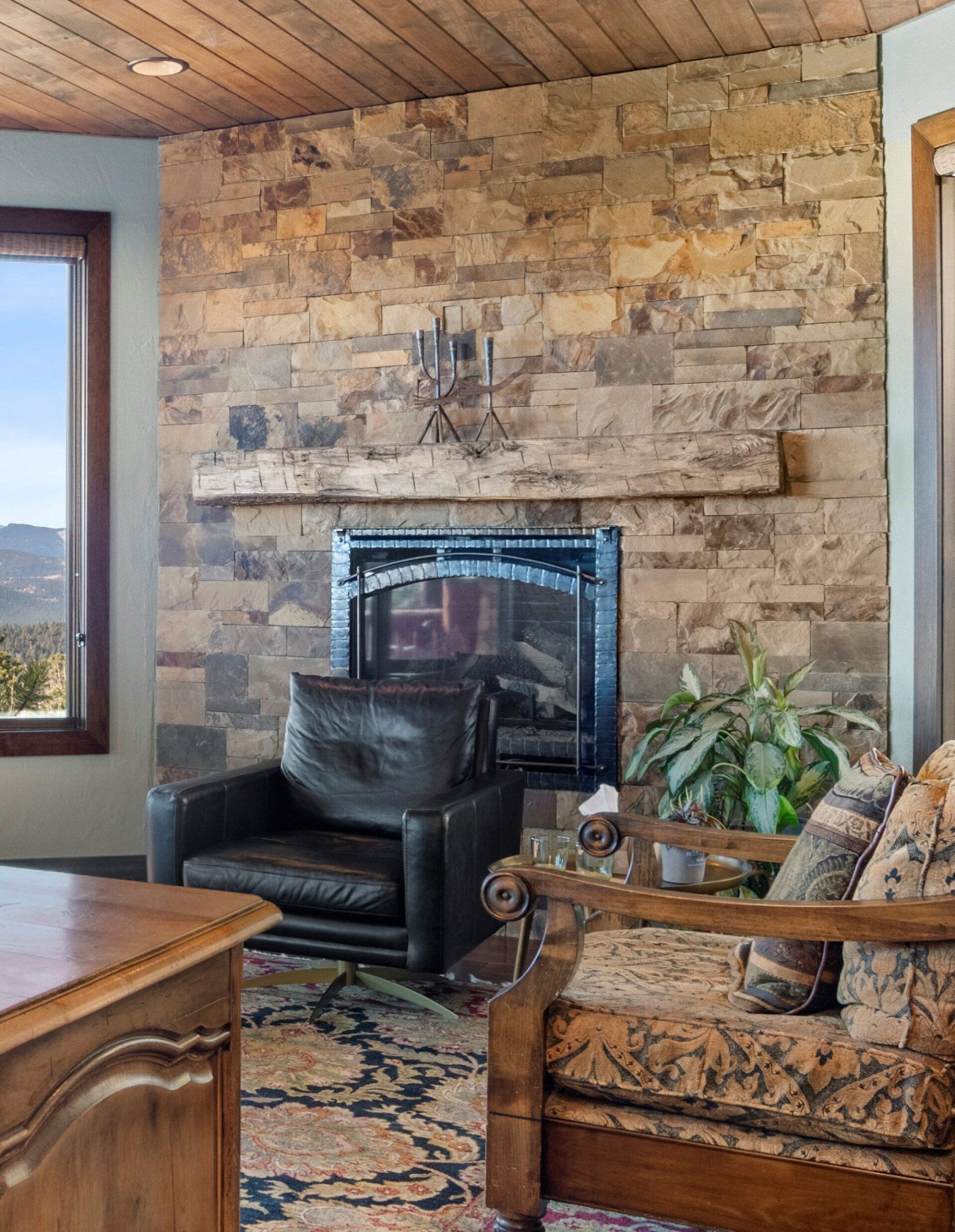 A living room with a fireplace , chairs and a desk.