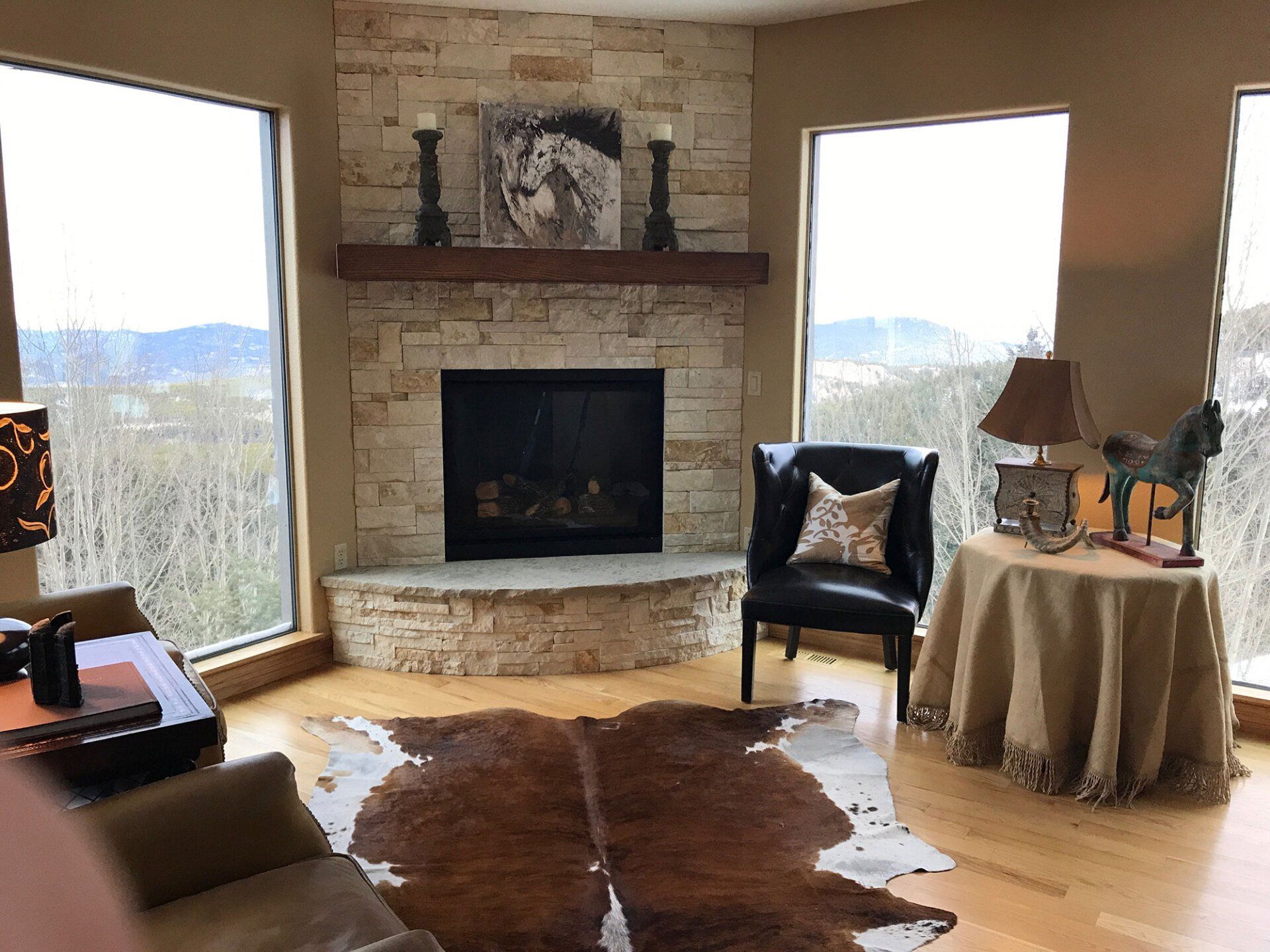 A living room with a fireplace and a cowhide rug