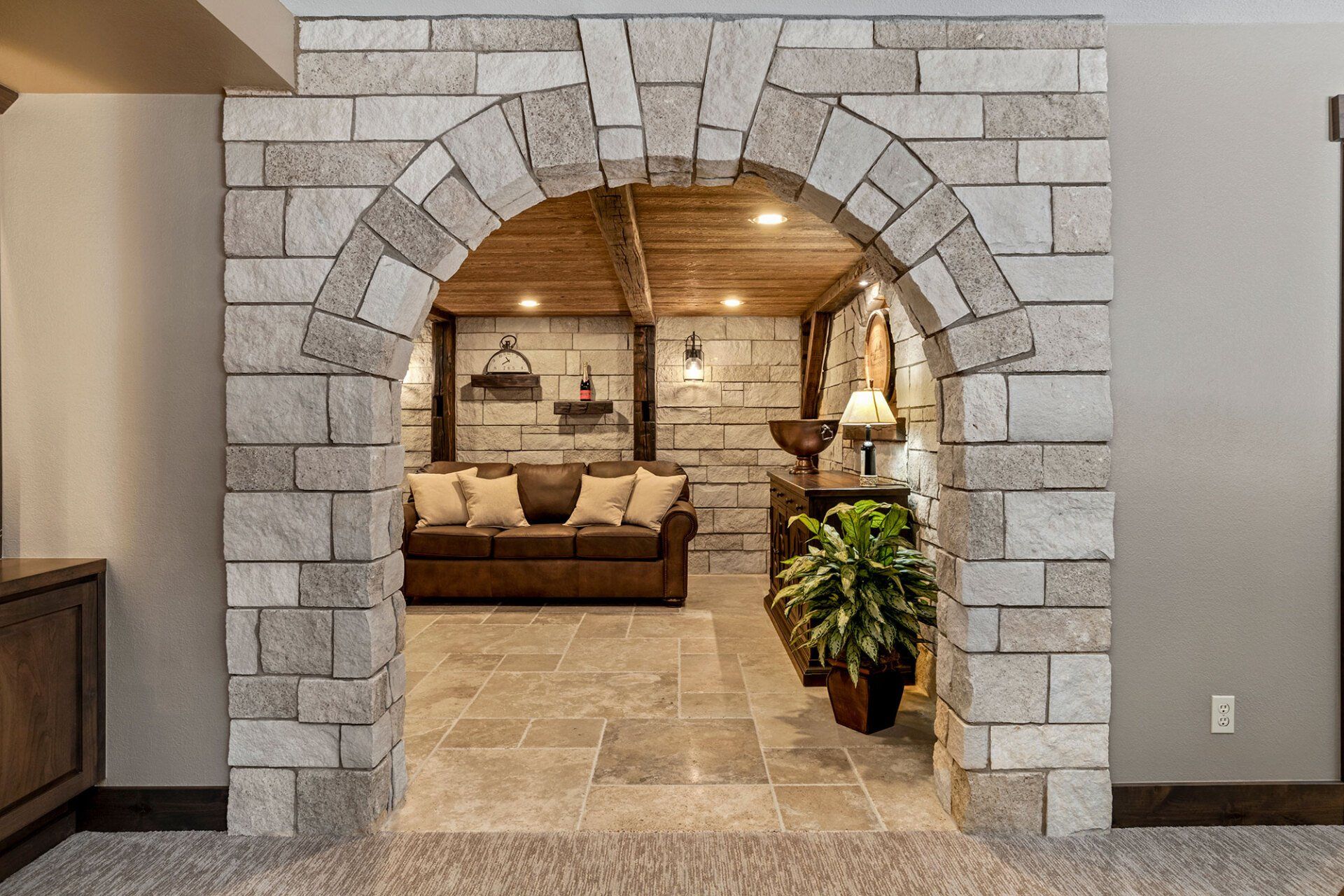 A living room with a brick archway leading to a basement.