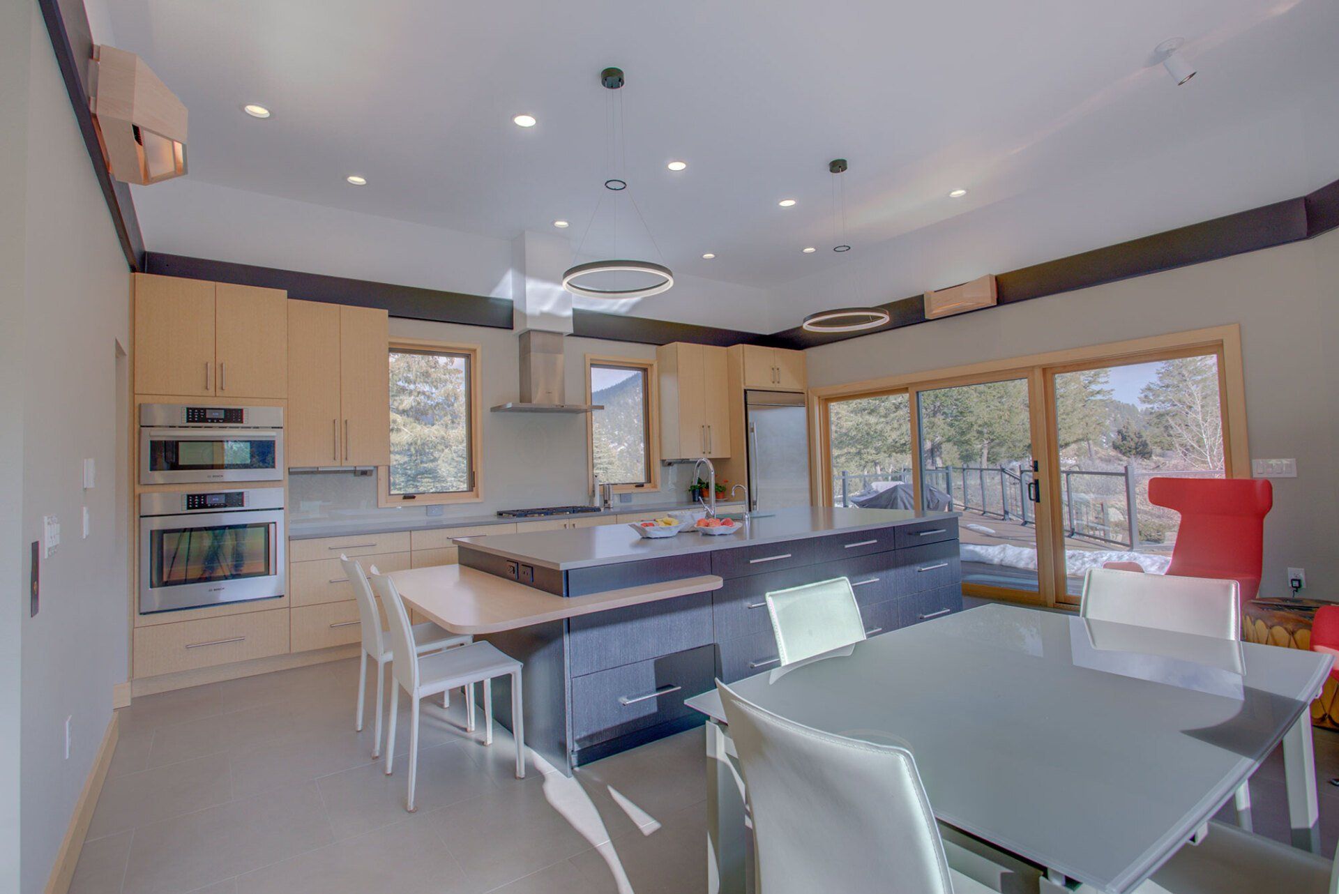 A kitchen with a dining table and chairs and a large island.