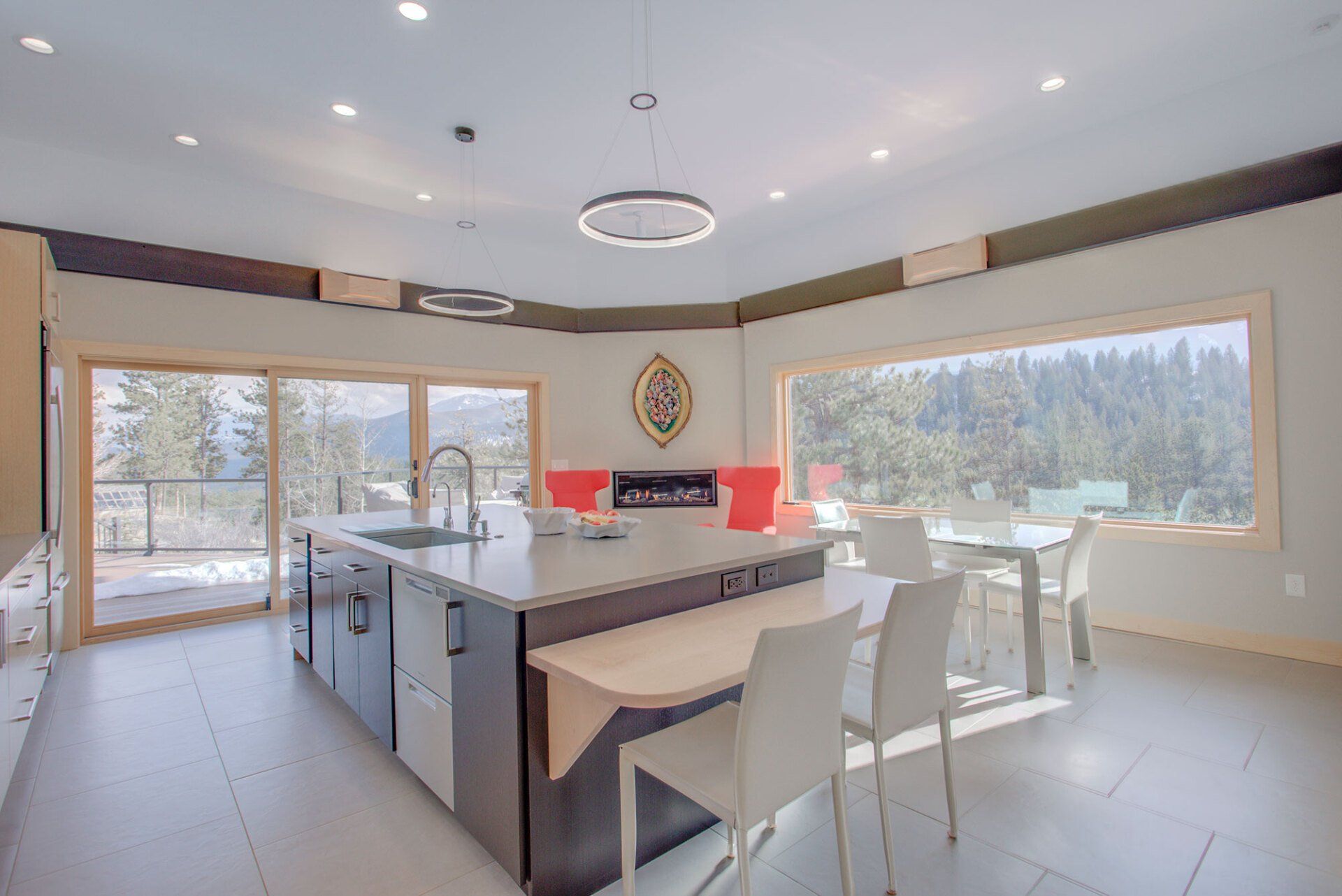 A kitchen with a large island and a table and chairs.