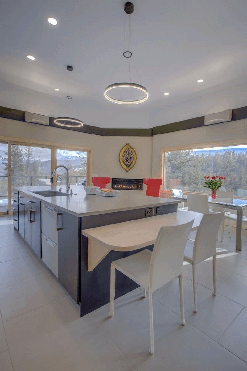 A kitchen with a large island , a table and chairs.