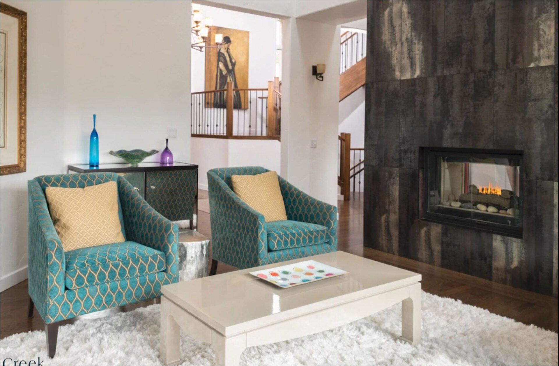 A living room with two chairs , a coffee table , and a fireplace.