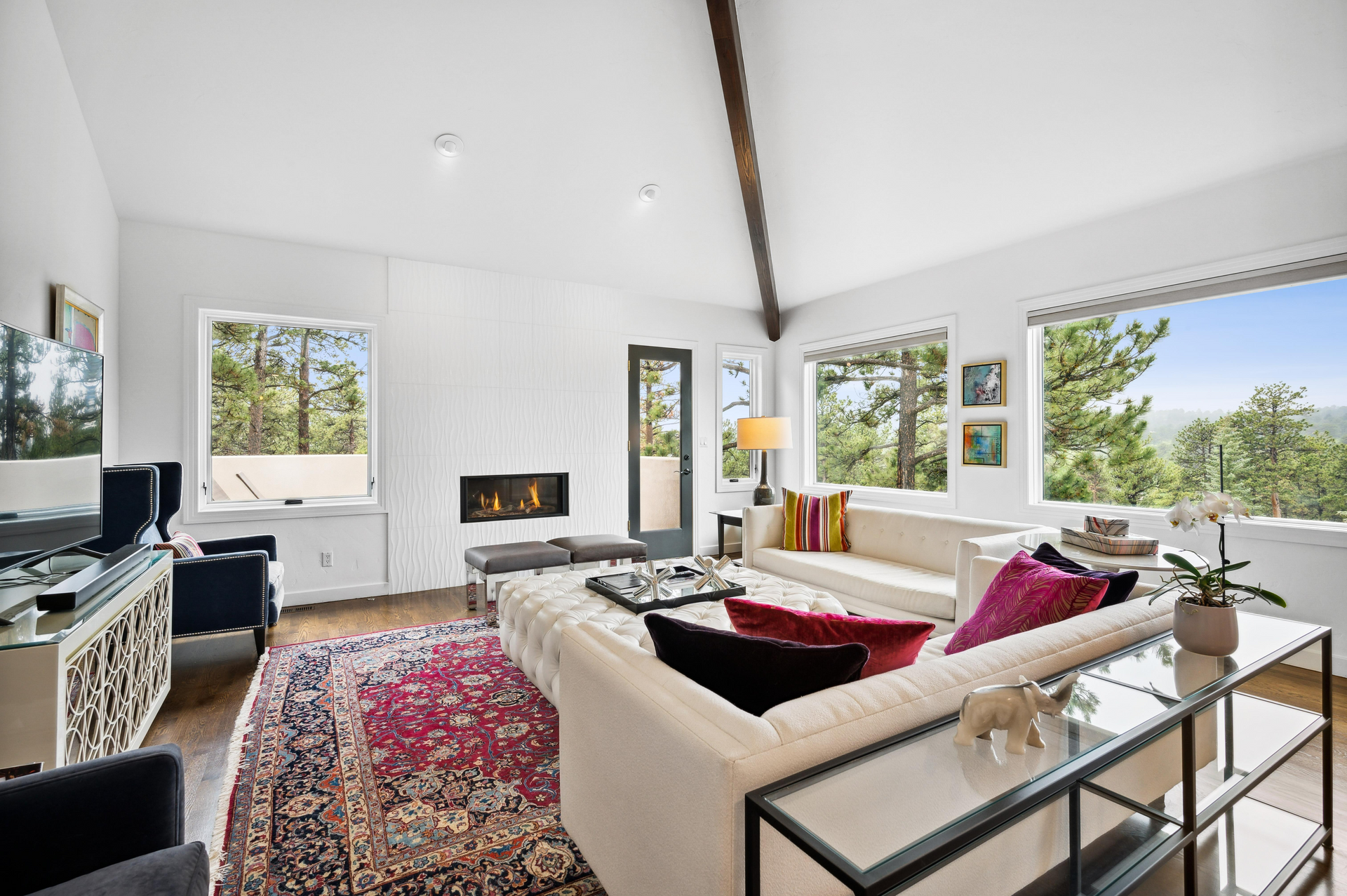 A living room with a couch , chairs , and a fireplace.