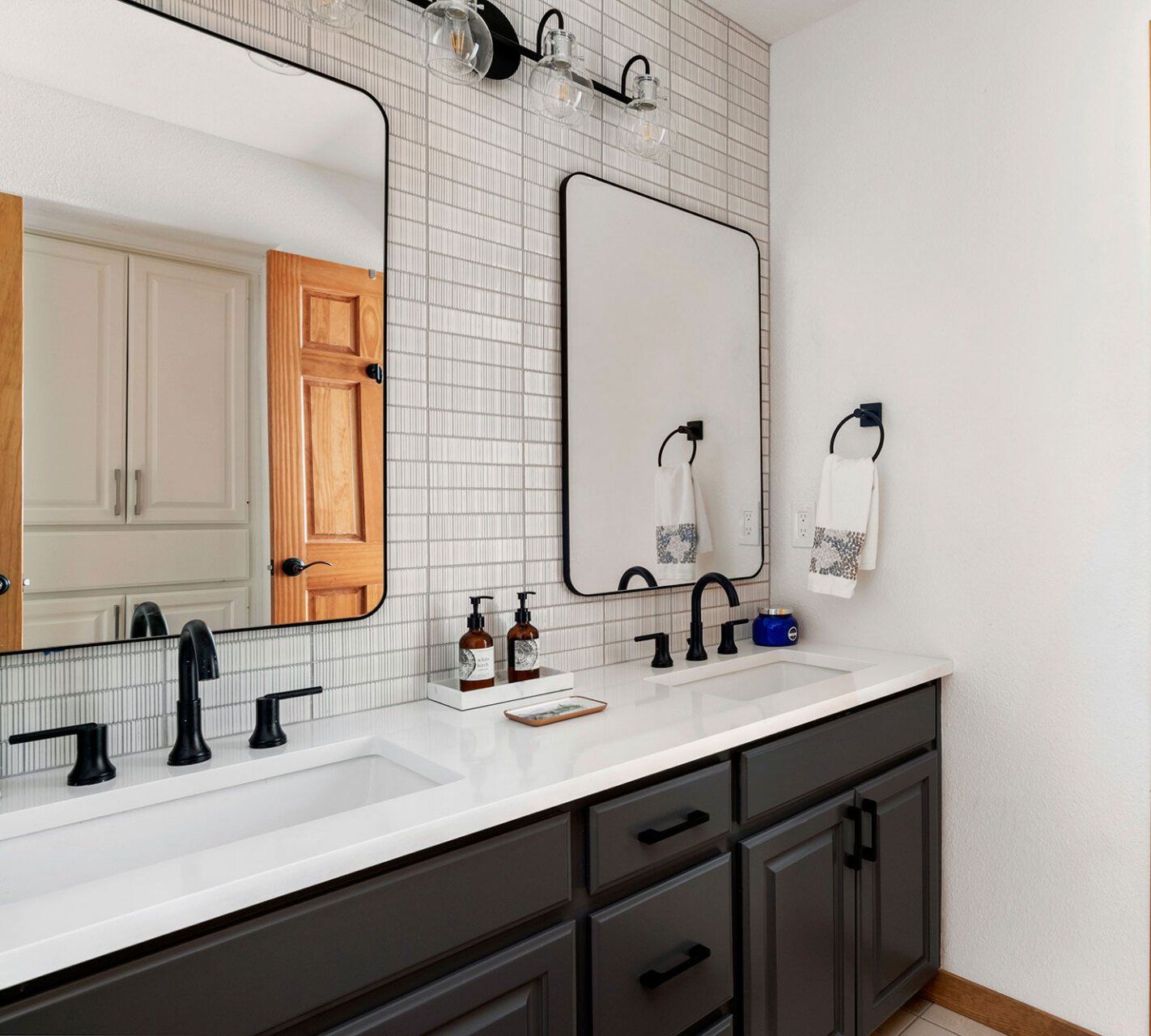 A bathroom with a sink , mirror and cabinets.