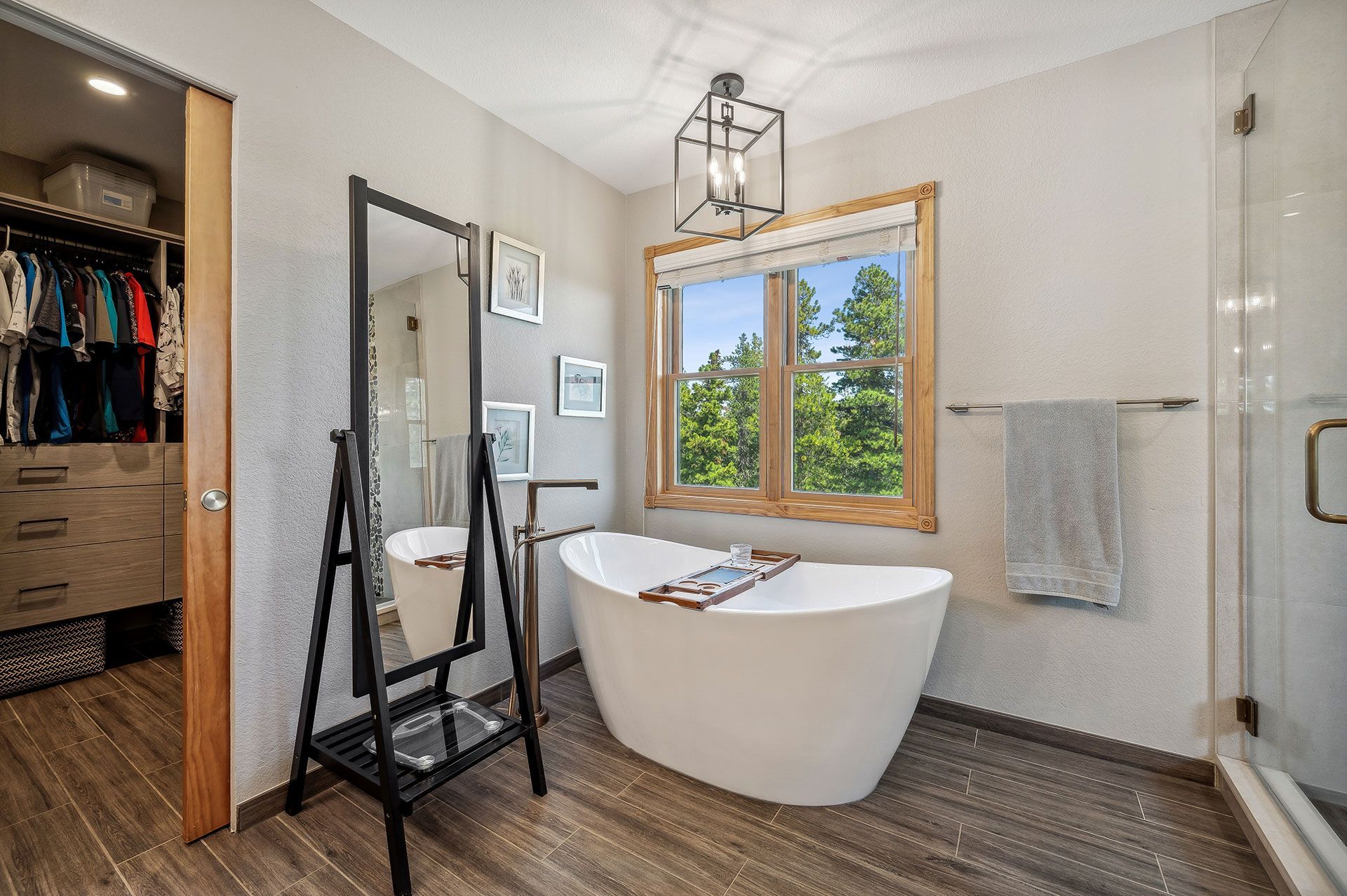 A bathroom with a bathtub , mirror , and walk in closet.