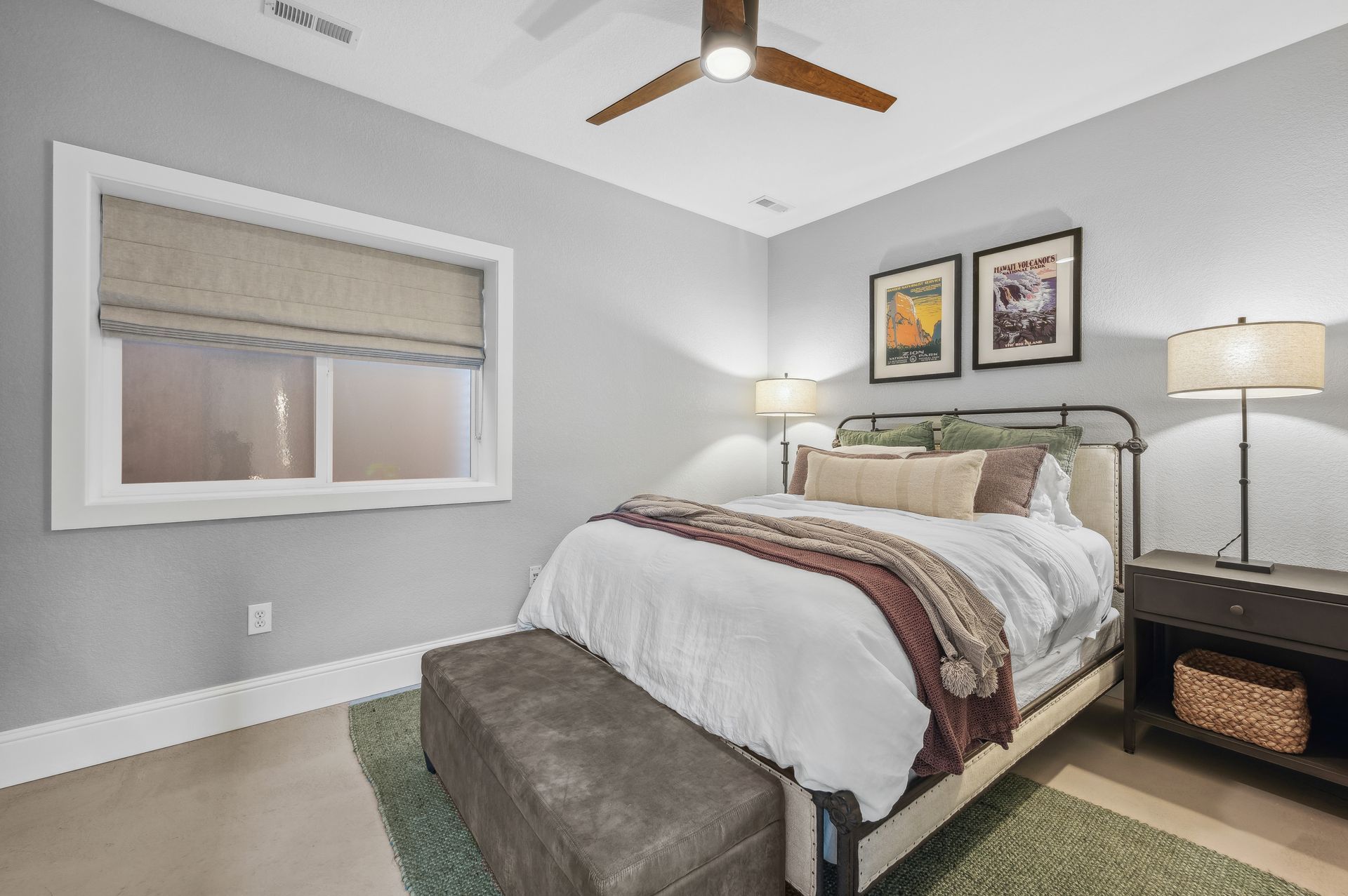 A bedroom with a bed , nightstand , lamps and a ceiling fan.