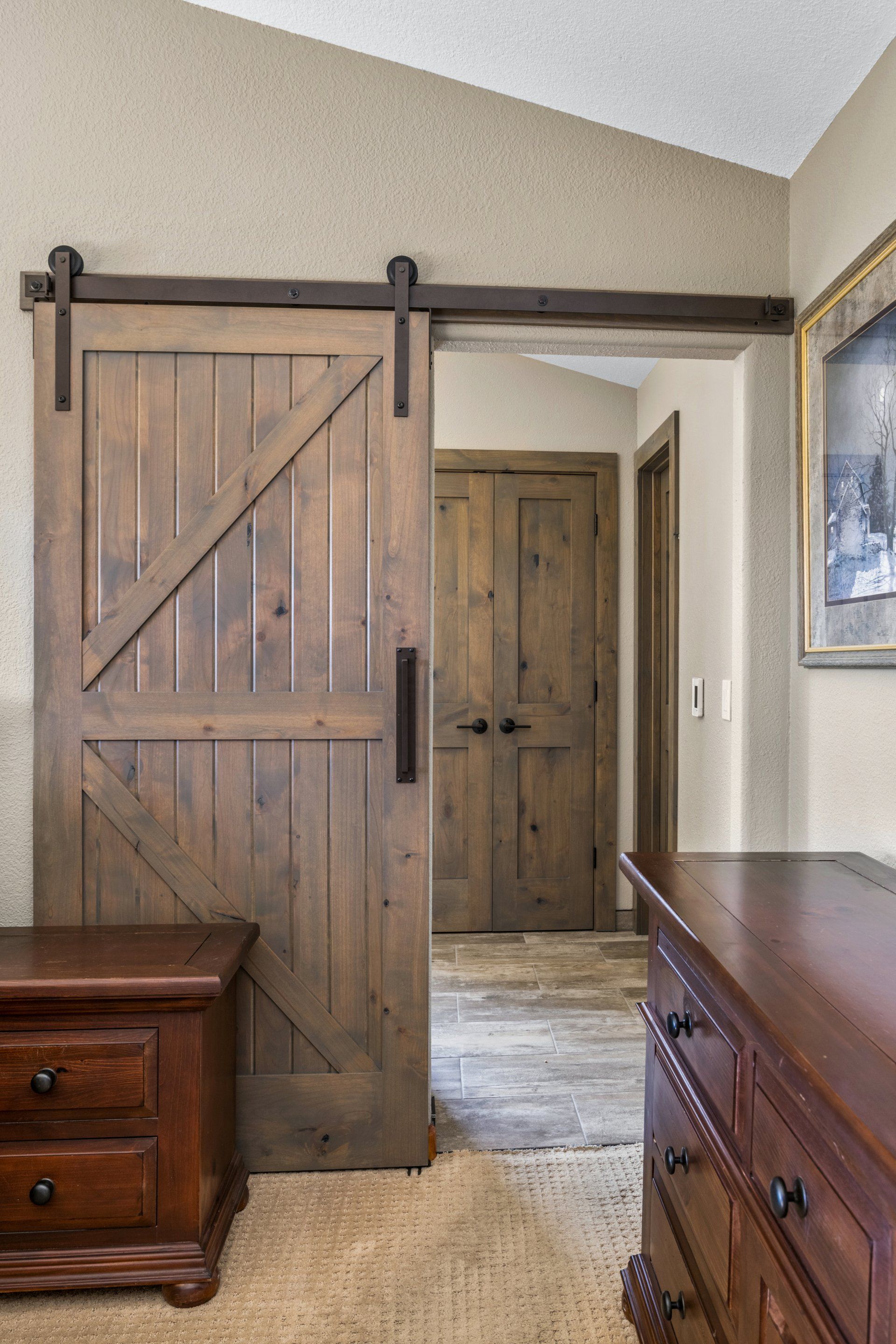 A bedroom with a sliding barn door and a nightstand.