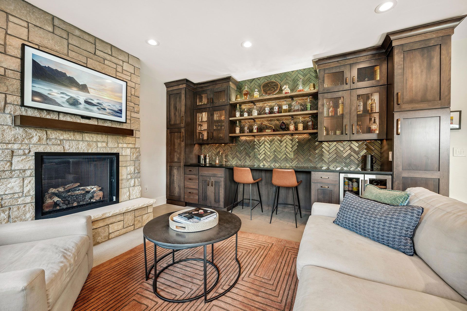 A living room with a fireplace , couch , table and chairs.