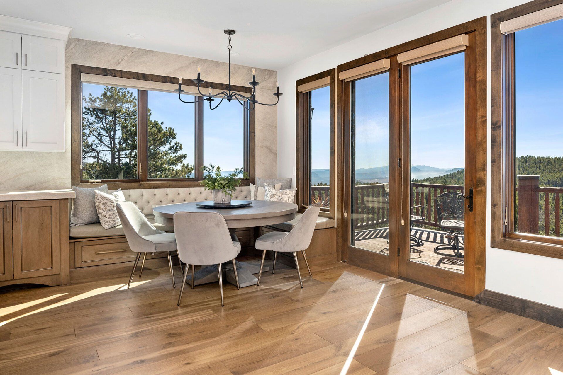 A dining room with a table and chairs and a lot of windows.