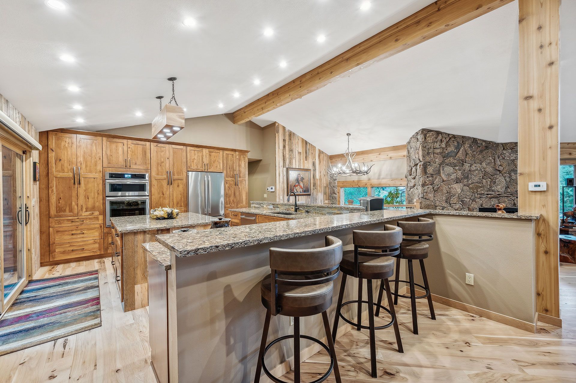 A kitchen with a large island and stools in it.