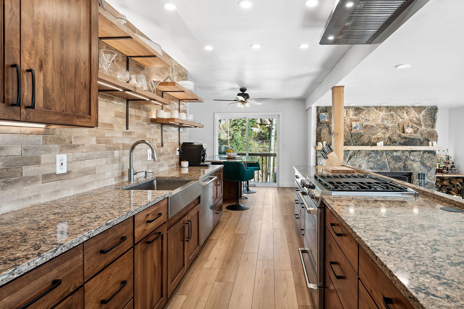 A kitchen with granite counter tops, wooden cabinets, and stainless steel appliances.