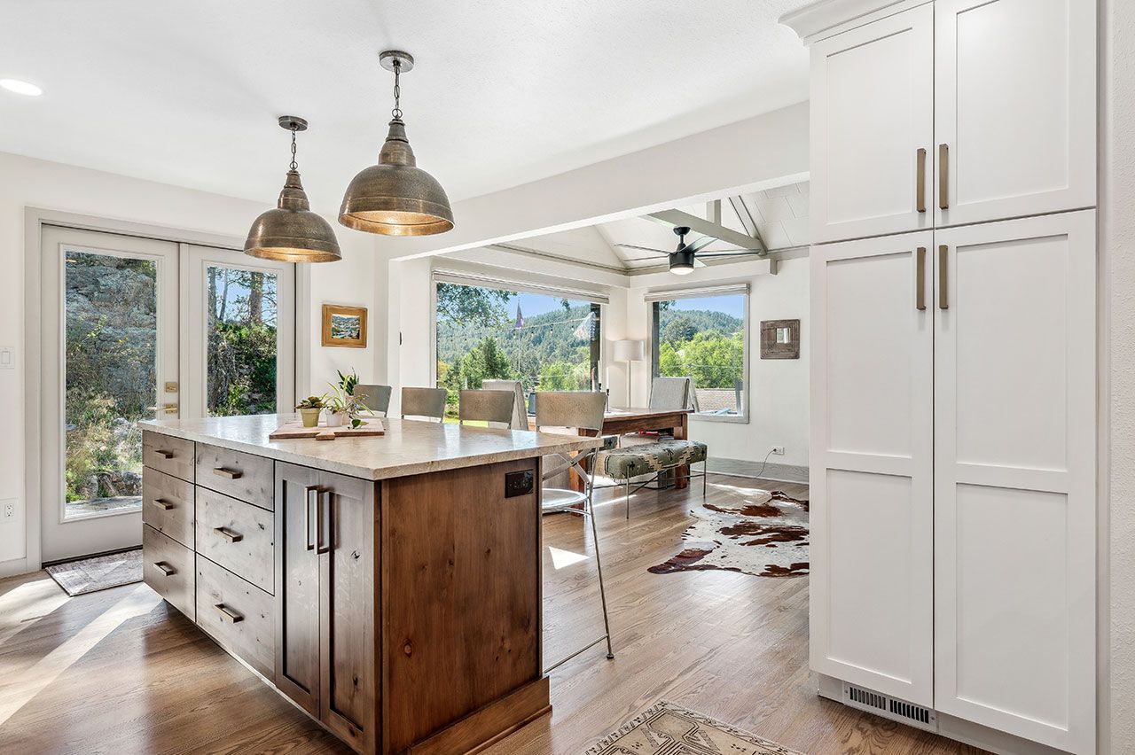 A kitchen with a large island and white cabinets.