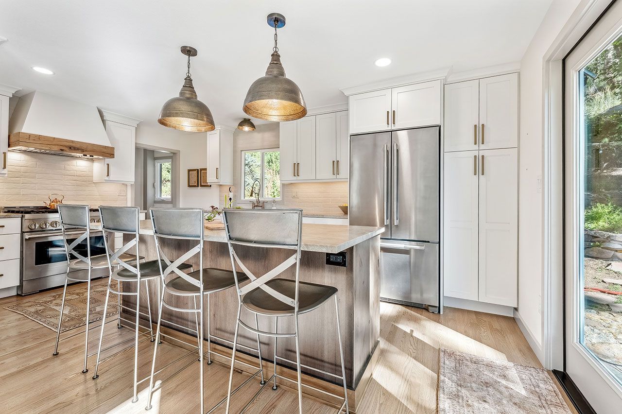 A kitchen with stainless steel appliances, white cabinets, and a large island.