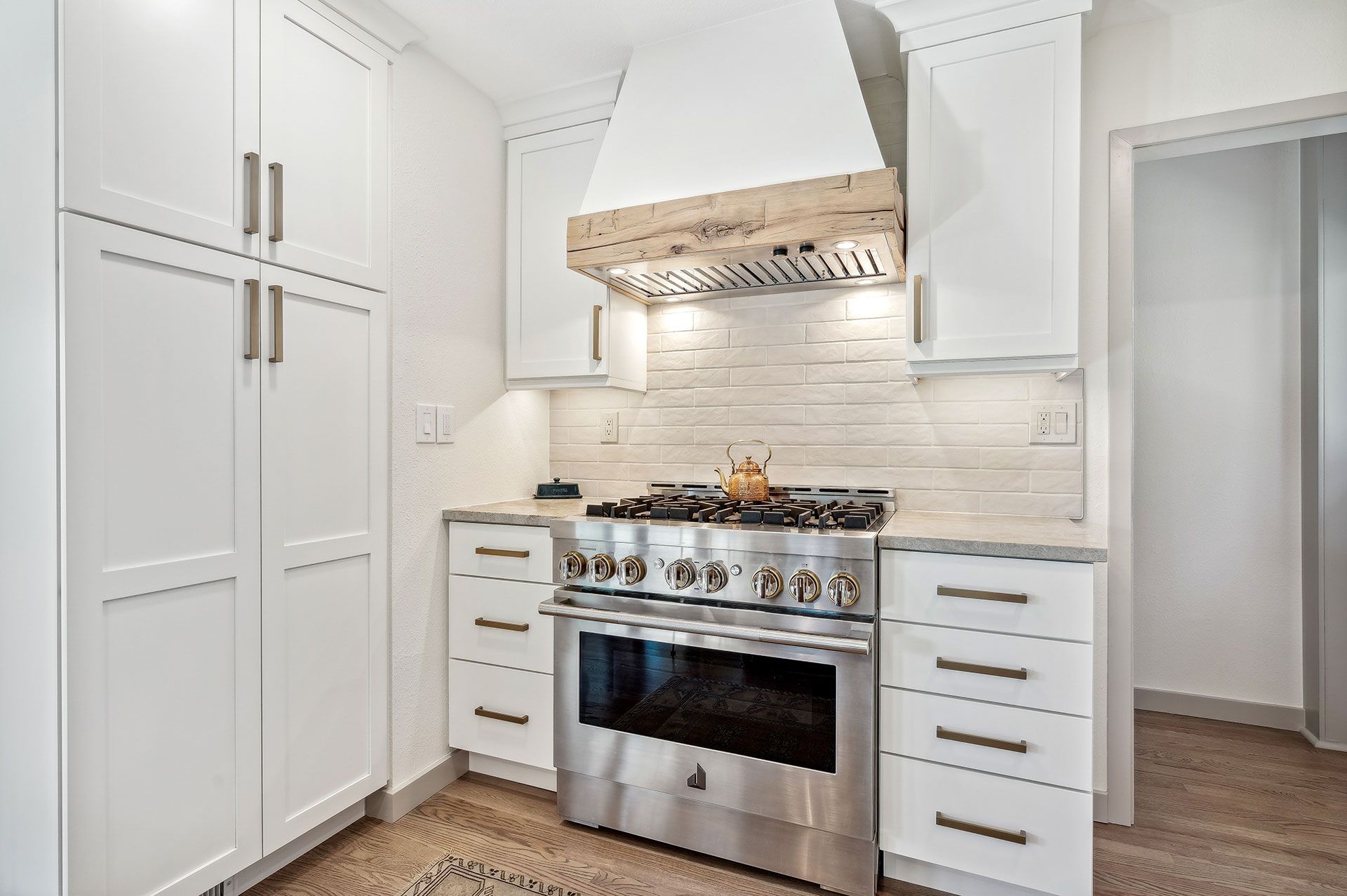 A kitchen with stainless steel appliances and white cabinets.